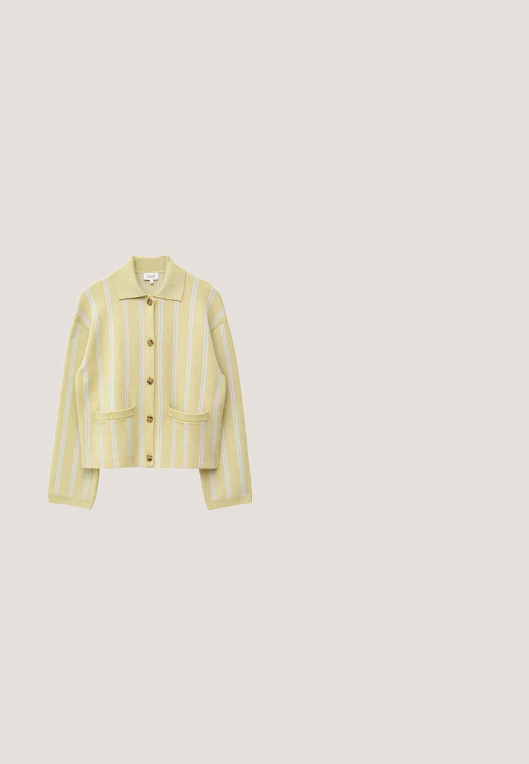 Cárdigan amarillo claro con rayas verticales blancas, botones carey, dos bolsillos delanteros y un cuello clásico.; Top peplum negro con flores y tirantes ajustables; presenta un estampado floral colorido en rosa y amarillo, cintura fruncida y un dobladillo con volantes.; Pantalones cortos a medida de color amarillo claro con cierre de botón, presillas para cinturón, pliegue frontal y corte hasta la rodilla sobre un fondo liso.; Zapato plano de ante marrón claro con puntera redondeada y cierre de cordones, mostrado sobre un fondo blanco, vista lateral.; Bolso pequeño tejido de color beige con asas largas negras, detalles de cuero negro y una pequeña etiqueta con la marca colgando de una de las asas.; Pulsera de brazalete de oro con una flor amarilla y un único detalle de hoja sobre un fondo claro simple.