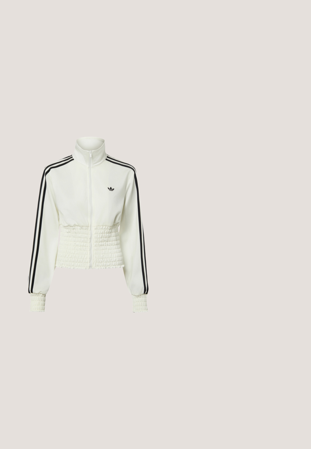 Witte Adidas trainingsjack met ritssluiting, zwarte strepen op de mouwen, gerimpelde taille en manchetten, en het Adidas trefoil-logo op de borst.; Zwart kort mouwshirt met witte rand aan kraag en manchetten, witte geperforeerde strepen langs de schouders en mouwen, klein Adidas-logo op de borst.; Witte shorts met elastische taille en losse pasvorm met een onregelmatig donkerbruin koeienprint.; Benen met geribbelde lavendelkleurige sokken met witte kruisbanden, gecombineerd met witte ballerina's met zwarte bies op een groene vloer.; Zwarte gepatenteerde leren handtas met een afgeronde vorm, dubbele handvaten bovenaan, zilveren accenten en een opvallend wit logo aan de voorkant.; Cuffarmband vervaardigd uit gedraaid zilverkleurig metaal, met een gevlochten ontwerp, open uiteinden en een gladde textuur.