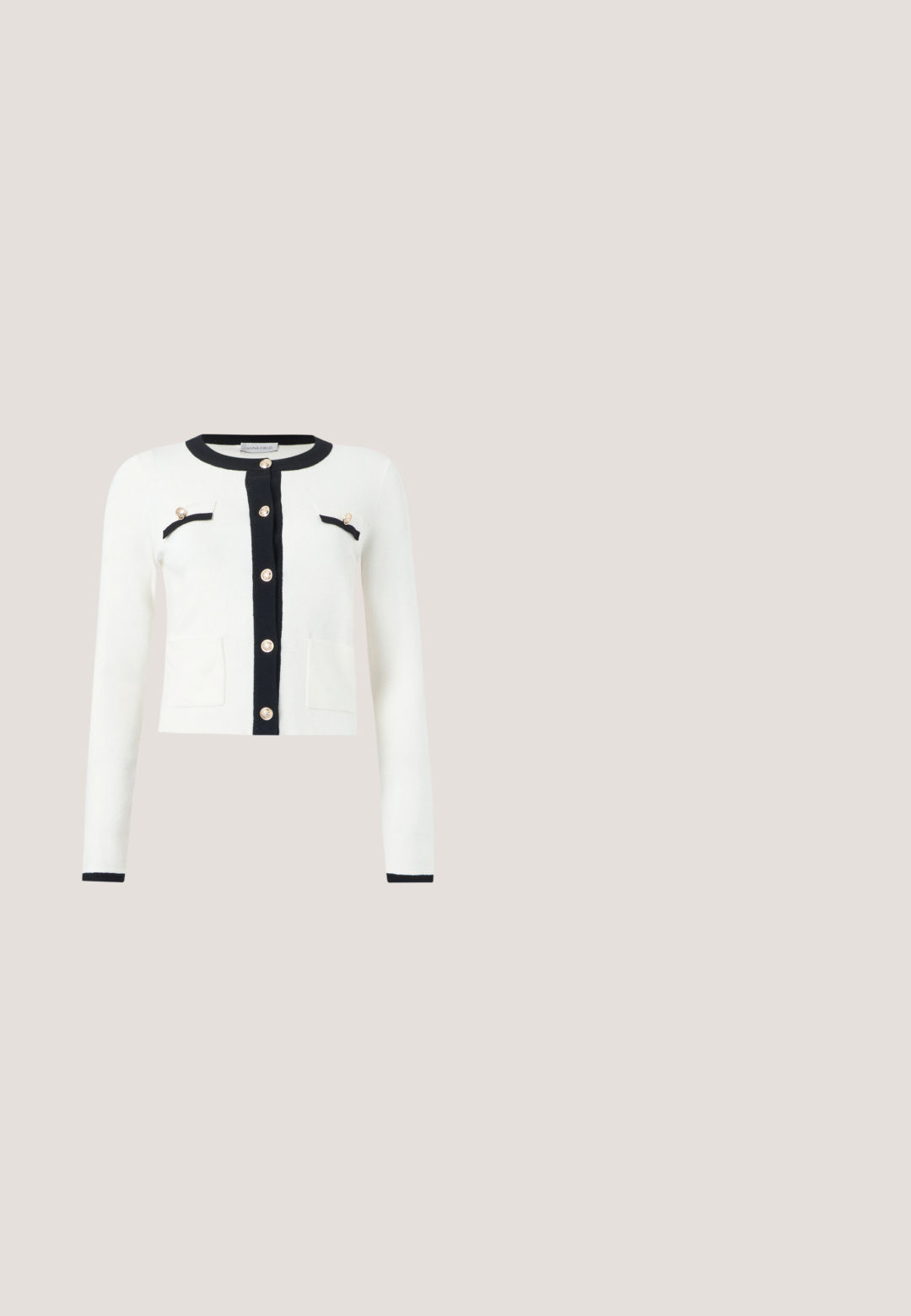 Cardigan blanc à manches longues avec bordure noire autour du col, patte de boutonnage, poches et boutons dorés sur le devant et les poches poitrine.; Haut noir à manches courtes en maille côtelée avec bordure blanche autour de l'encolure en U et une petite découpe en forme de goutte d'eau maintenue par un bouton doré.; Pantalon noir taille haute en denim. Coupe à jambes larges avec quatre boutons dorés en décoration sur le côté. Texture lisse et coupe ajustée.; Talons aiguilles en cuir noir avec un talon bloc et un petit nœud décoratif, posés sur un sol gris avec un mur vert foncé en arrière-plan.; Sac à main en cuir noir avec doubles poignées, bandoulière amovible et détail de fermoir doré sur la ceinture avant.; Collier délicat à double chaîne en or avec de petites perles blanches espacées régulièrement sur un fond clair uni.