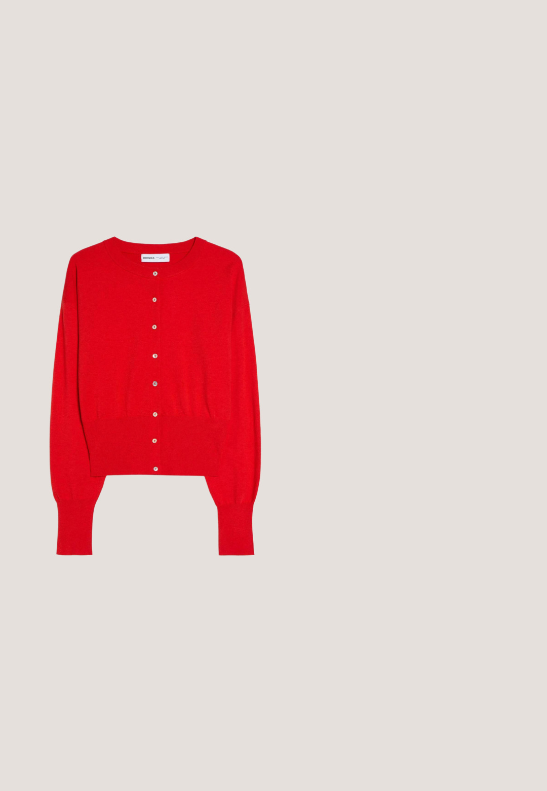 Cardigan rouge à manches longues coupé court avec encolure ronde, poignets et ourlet côtelés, et boutons blancs sur le devant.; Débardeur rouge sans manches avec un col rond, confectionné en tissu de coton doux. Présente un design épuré et un ourlet droit. Sans motifs ni ornements.; Pantalons sur mesure rouges avec une texture lisse, présentant un design à jambe droite, des poches avant et des coutures nettes sans matériel visible.; Sandale à talon en cuir rouge avec boucle pour l’orteil, bride de cheville avec boucle, semelle noire et talon bloc.; Sac à bandoulière en cuir rouge avec une forme arrondie, affichant une texture lisse, des accessoires en or et une bandoulière ajustable. Logo embossé à l'avant.; Boucles d'oreilles en forme de cerise rouge avec une finition pailletée, tiges en métal doré et feuilles en émail vert. Les détails en forme de cerise accentuent le design.