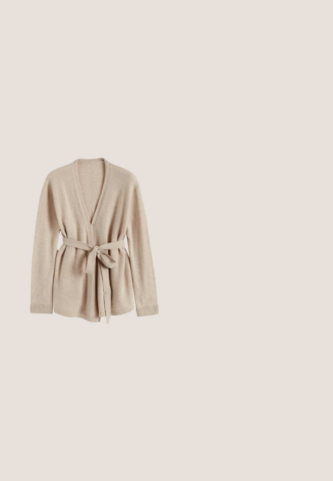 Beige vest gemaakt van zachte stof, met een V-hals, lange mouwen, een ceintuur in de taille en geribbelde manchetten.; Beige langemouwige bodysuit met gedrapeerde voorkant, zachte textuur en drukknoopsluiting onderaan. Elegante en aansluitende ontwerp.; Lange, gelaagde rok van zachte mauve kant en tule. Voorzien van ruches, ingewikkelde kantpatronen en een gerimpelde tailleband voor extra textuur.; Ballet flats van zacht rozenhuid-suède met een ronde neus en een klein strikdetail aan de voorkant, met een lage platte zool.; Gouden ketting met een kleine, ovale witte parel als hanger, voorzien van een delicaten sluiting en verstelbare lengte voor een perfecte pasvorm.; Roze elastisch haarbandje met een zachte stoffen bloem met gelaagde bloemblaadjes in het midden op een witte achtergrond.