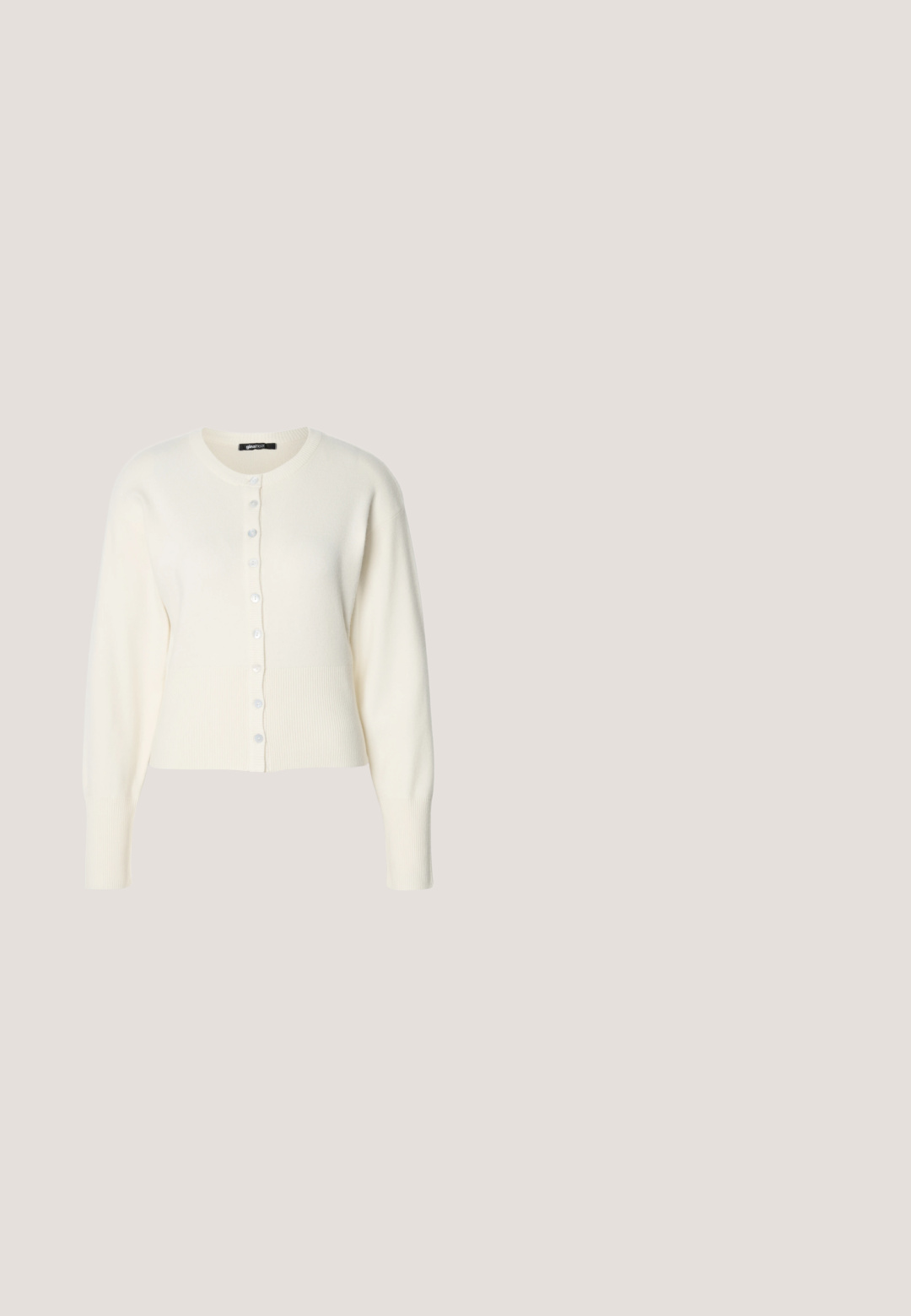 Witte gebreide cardigan met geribde zoom en lange mouwen, met een ronde hals en een rij blauwe knopen aan de voorkant.; Zwart mouwloos topje met ribbelachtig bovenstuk en een uitlopende, geplooide peplum onderkant. Soepele textuur met een egale kleur door het hele ontwerp.; Zwarte leren rok met een uitlopende silhoët, voorzien van zichtbare stiksels en een gladde textuur. Middellange ontwerp met een klassieke snit.; Zwarte leren balletschoen met elastische achterkant, rustend op een gestructureerd buitenpad met een betegelde muur op de achtergrond.; Kleine zwarte glanzende handtas met twee lange hengsels en zijkant trekkoord details op een effen lichte achtergrond.; Een paar gepolijste zilveren halve maanvormige creolen met heldere plastic achterkanten op een witte ondergrond.