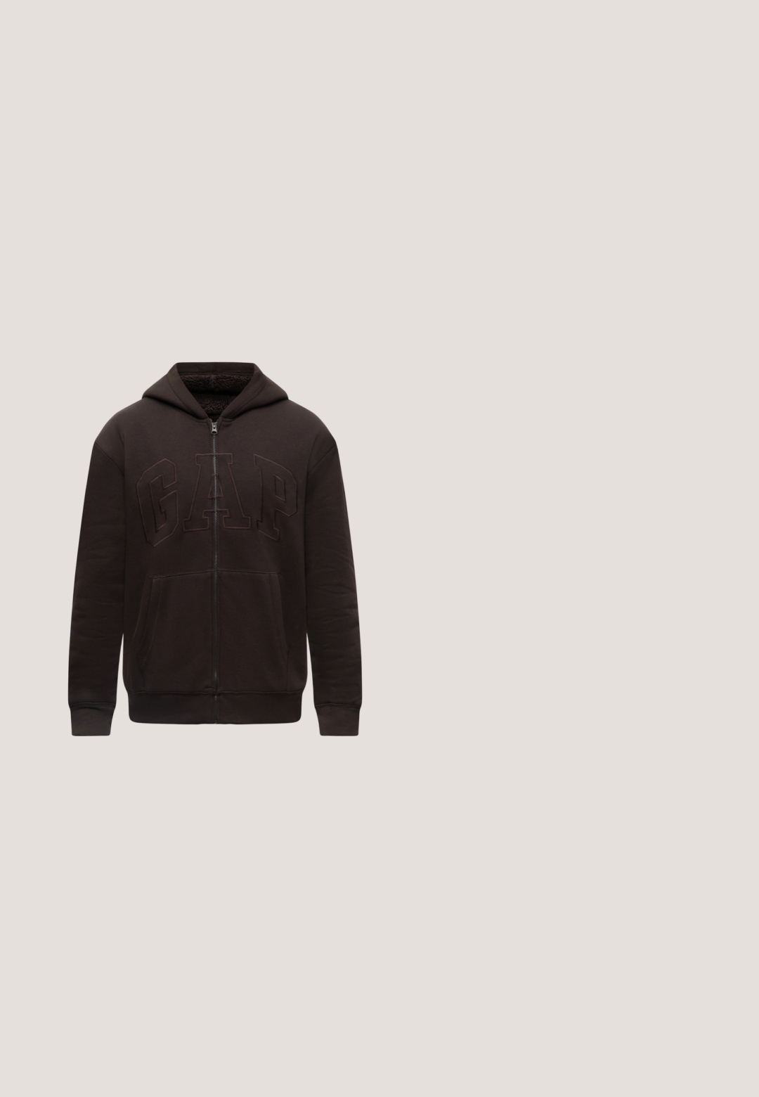 Sweat à capuche noir zippé avec poches avant, capuche et logo GAP brodé en relief sur la poitrine, présenté sur un fond clair uni.; Veste sans manches marron avec col montant et fermeture éclair intégrale à l'avant, fabriquée en tissu léger légèrement brillant, présentée à plat sur un fond blanc.; T-shirt beige à manches courtes et col rond avec détail de col côtelé rayé, vu de face sur fond blanc uni.; Pantalon cargo marron avec taille élastique, cordon de serrage, poche latérale avec rabat et poignets élastiques.; Basket basse en daim marron foncé avec semelle et lacets beige, avec un petit logo doré "Paul Smith" sur le côté.; Sac polochon matelassé vert olive avec poignées noires, coins en cuir et bandoulière amovible sur fond blanc.