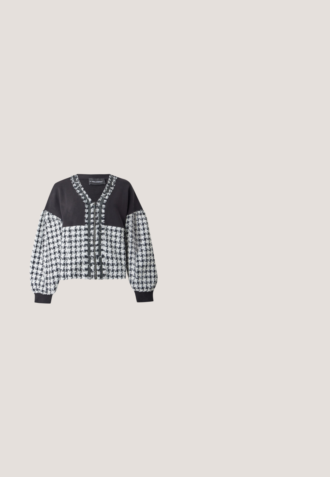 Black and white houndstooth patterned cardigan with solid black yoke, long puffed sleeves, fringed trim, and V-neck collar.; Black short-sleeve t-shirt with scattered large and small white polka dots and a small white graphic of a face wearing sunglasses near the collar.; Black high-waist wide-leg faux leather pants with front patch pockets and visible seam detailing on a plain light background.; Person wearing black Karl Lagerfeld slip-on sandals with multiple straps, standing on wooden floor, skirt with black and white architectural prints.; Black tote bag with white polka dots and small white abstract face illustrations, featuring two black shoulder straps.; Silver hoop earrings with the word "Perfect" spelled out in rhinestones inside each hoop on a white background.