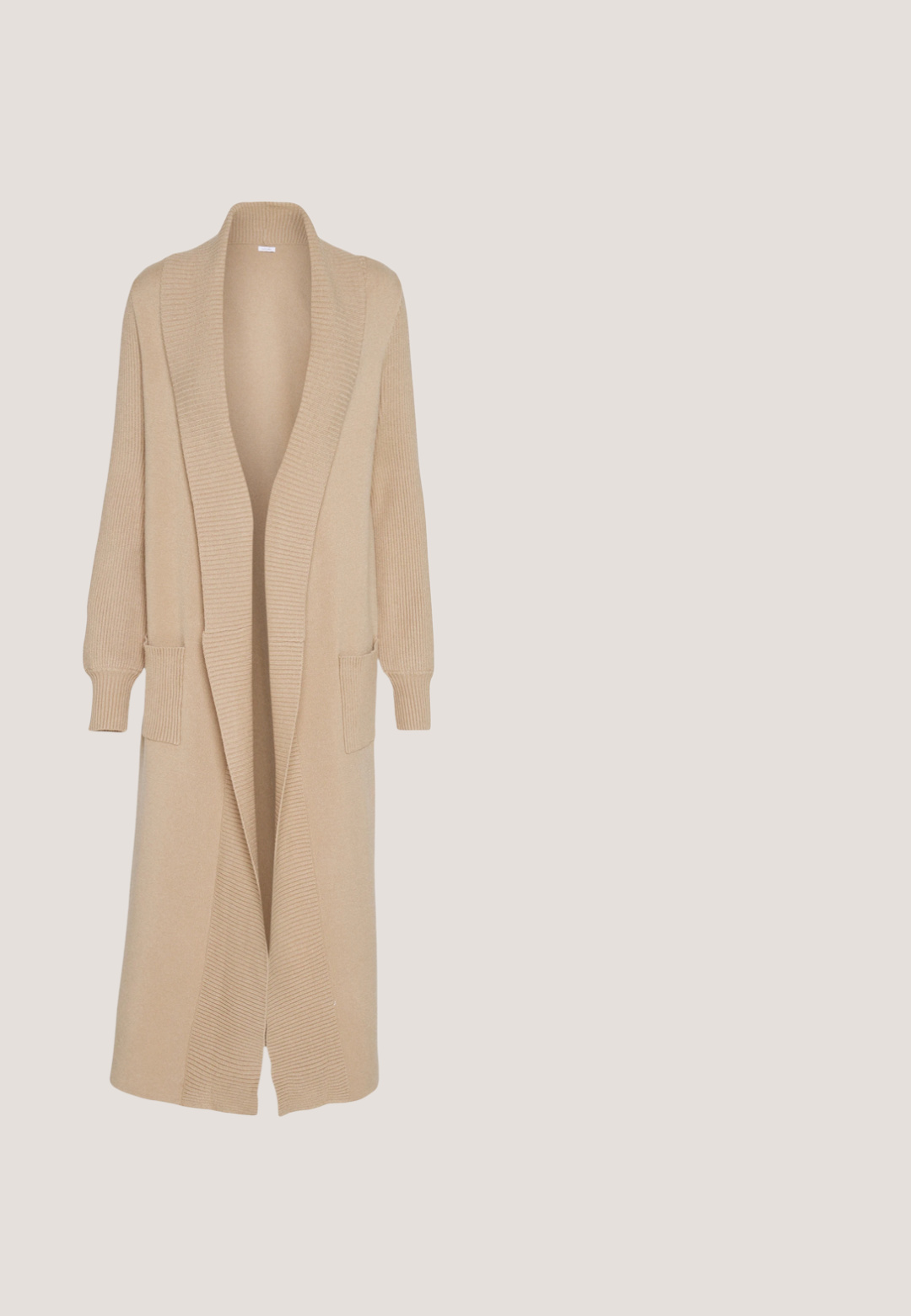 Cárdigan de punto beige con cuello tipo chal, abertura frontal, puños de manga acanalados y dos bolsillos frontales. Textura suave y diseño largo.; Top negro de manga larga tipo cuello alto, hecho de una tela suave y elástica con una silueta ajustada y un cuello alto. Sin patrones ni adornos.; Jeans skinny negros de denim, con cintura alta, cinco bolsillos y cierre de botón. Textura suave con sutiles detalles de costura.; Zapatilla de cuero blanca con logo V de goma negra. Suela texturizada en blanco roto, cordones blancos y detalle en el talón trasero con el nombre de la marca en negro.; Bolso tote negro hecho de material texturizado, con dos asas largas y un diseño simple y minimalista sin herrajes visibles.; Anillo en tono dorado que presenta dos bandas entrelazadas; la parte superior es pulida y reflectante, mientras que la parte inferior tiene un acabado mate.