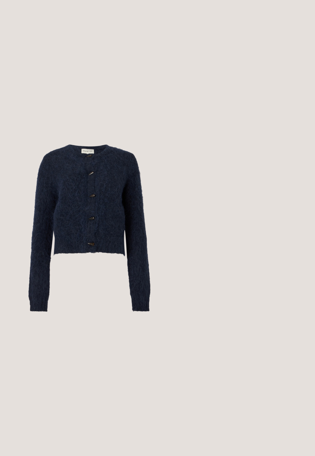 Cardigan en maille duveteuse bleu foncé avec manches longues, encolure ronde et quatre boutons à bascule noirs sur le devant.; Haut à manches longues en ribbed bleu marine avec un col rond, présentant un détail torsadé décoratif et un petit accent métallique.; MUNTHE DLIFF - Pantalon classique - navy; Mocassins en daim bleu marine avec un design cousu, profil bas et texture lisse. Caractérisés par un style à enfiler et une doublure intérieure rose clair.; Sac fourre-tout bleu marine avec garniture marron et double anses, équipé d'une bandoulière réglable avec boucle dorée et petit détail de bouton doré.; Boucles d'oreilles créoles en or avec des formes irrégulières de croissant remplies d'émail bleu foncé brillant, présentées sur un fond blanc.