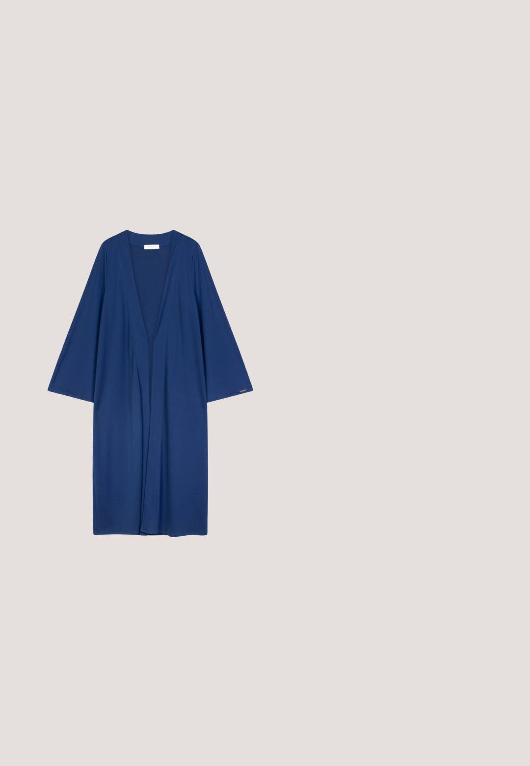 Longue robe style kimono bleu marine à manches larges, en tissu lisse, avec un décolleté en V profond et une silhouette décontractée.; Débardeur bleu marine sans manches avec col rond, étiquette Tommy Hilfiger visible à l'intérieur du col, posé à plat sur fond blanc.; Pantalon sur mesure bleu marine avec passants pour ceinture, poches avant et coupe fuselée avec petites fentes latérales à l'ourlet.; Mocassin plat noir avec semelle couleur tan, détail bride pour monnaie et logo doré "TH" sur le talon, présenté sur fond neutre.; Sac cabas en cuir noir avec longues anses, petit logo doré au centre et pochette bleue zippée avec fermoir attachée.; Paire de petites boucles d'oreilles clous en forme de cœur de couleur or avec un détail en ligne verticale et un texte gravé de chaque côté.