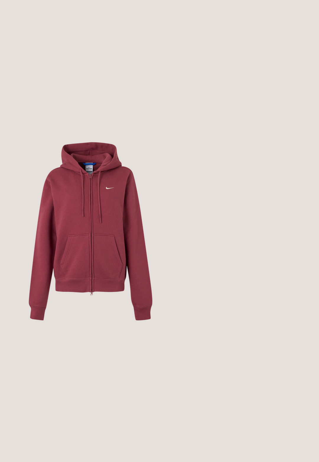 Bordeaux rød hættetrøje med lynlås, forlommer, snøretræk i hætten, ribkanter og et lille hvidt Nike-swoosh på brystet.; Sort Nike sports-bh med brede stropper og hvid Nike swoosh-logo centreret foran.; Sort cykelshorts med høj talje lavet af elastisk stof med en glat tekstur og uden synligt hardware eller pynt.; Diverse sko i lyserød og beige med teksturerede sidelapper, brune detaljer og fleksible såler. Bæres sammen med blå leggings og hvide sokker.; Vinrød Nike tote-taske med sorte håndtag og hvid Nike swoosh-logo foran, mod en hvid baggrund.; Sorte fingerløse handsker med et tekstureret design. Lavet af et åndbart materiale, med en tommelfingeråbning og forstærket håndflade for bedre greb.