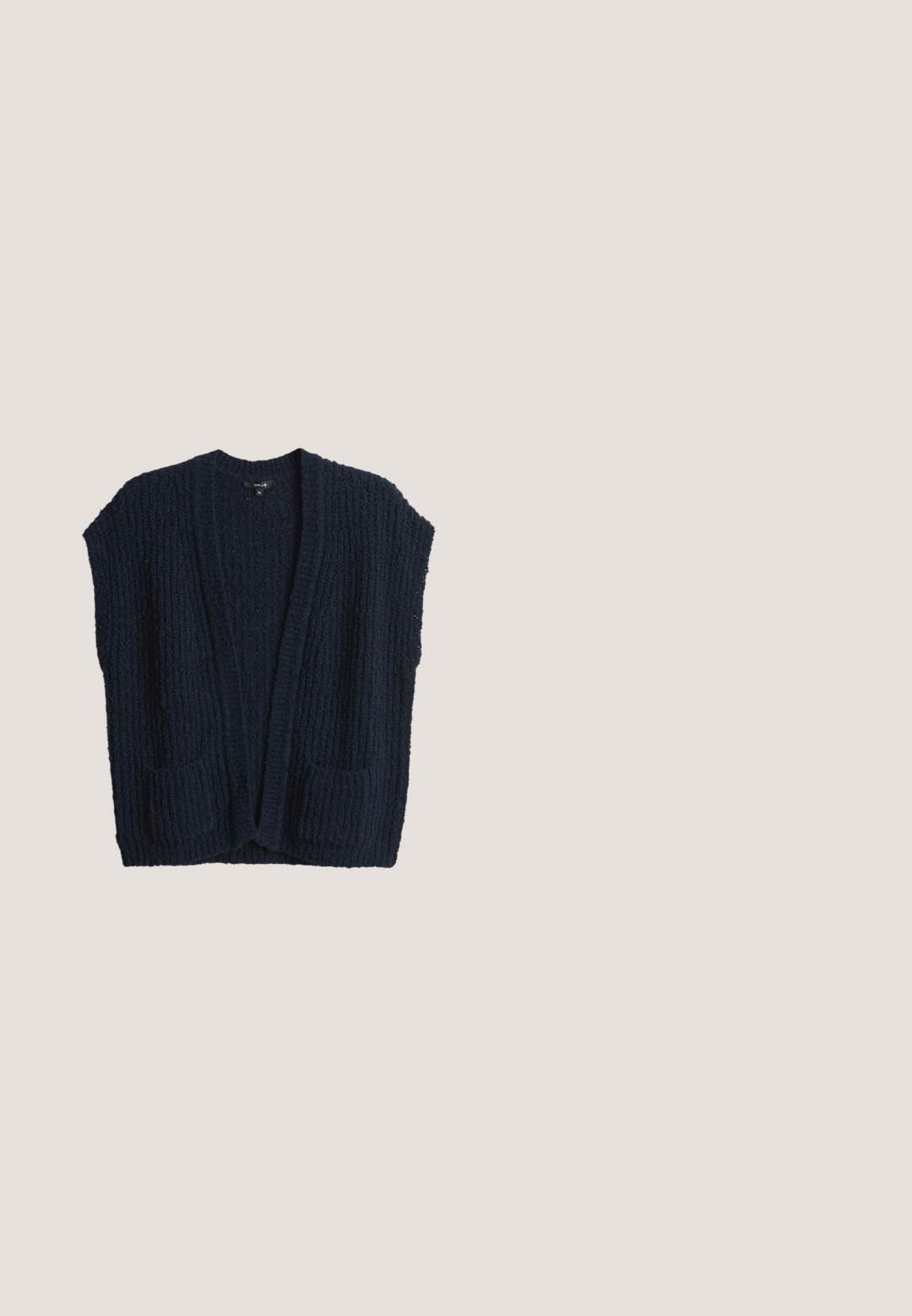 Cardigan en tricot bleu marine avec une surface texturée, sans fermeture à l'avant et deux poches avant. Design sans manches et matière en tricot épais.; Haut en maille gris foncé à manches courtes avec encolure ronde et détail de couture centrale à l'avant, posé à plat sur fond blanc.; Pantalon à jambes larges en tissu bleu marine foncé, présentant des plis structurés, des poches latérales et une texture lisse. Design classique de la ceinture.; Chaussure bateau bleu marine à enfiler avec motif ventilateur perforé et semelle épaisse blanche dotée de rainures verticales pour la flexibilité et l'adhérence.; Lunettes de soleil rectangulaires grises avec des verres bleu foncé. La monture présente un design translucide et des accents texturés sur les branches.; Sac bandoulière en cuir bleu marine avec sangle ajustable, deux poches avant à boucle, une poche zippée et des poches latérales ouvertes.