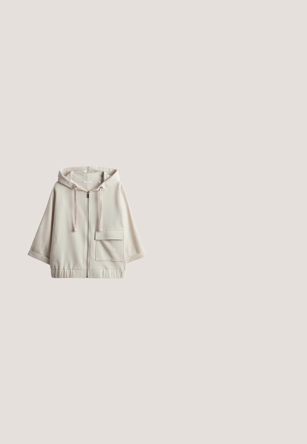Beige hooded zip-up sweatshirt met een grote voorzak, een losse pasvorm, elastische tailleband en een soepele katoenmix textuur.; Roomkleurig mouwloos vest met rits, opstaande kraag en twee voorzakken, plat gelegd op een witte achtergrond.; Wit shirt met korte mouwen, ronde hals en dunne zwarte strepen op de mouwboorden.; Beige geplooide broek met een wijdere pijp, gemaakt van een gladde stof. Voorzien van een elastische tailleband en zijzakken voor functionaliteit.; Beige sportieve schoen met een gestructureerde mesh bovenzijde, een gladde rubberen zool en een minimalistisch ontwerp. Inclusief vetersluiting aan de voorkant en gevoerde kraag.; Beige zachte stoffen draagtas met brede gewatteerde handvatten en een glad voorvak met label Kapten & Son.