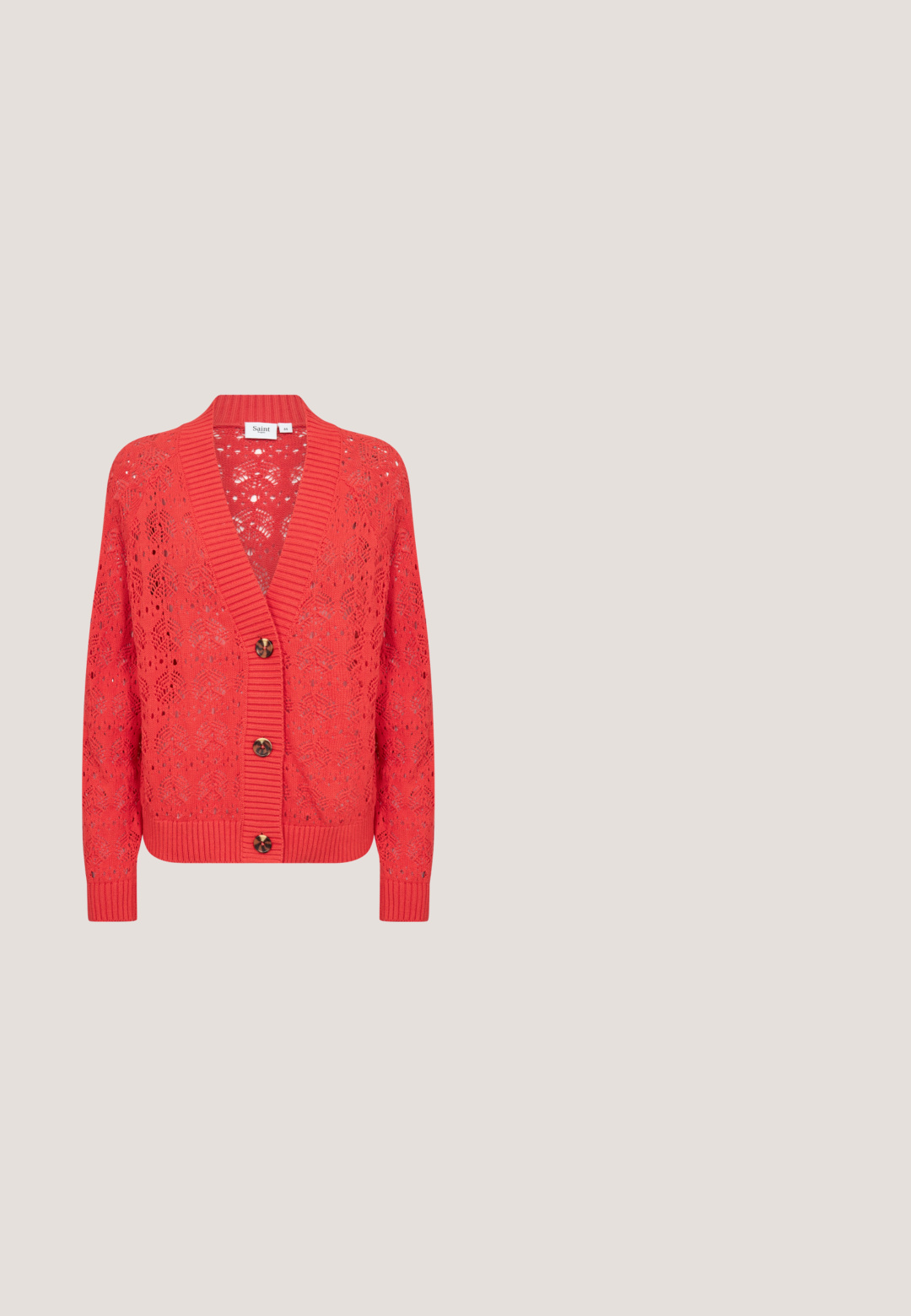 Rode gebreide cardigan met een open weefpatroon, geribbelde manchetten en een diepe V-hals. Voorzien van drie bruine knopen aan de voorkant.; Oranje gebreide crop top met grote witte bloemenpatronen, vierkante halslijn en brede banden. Getextureerde stof met een aansluitende pasvorm.; Rode en witte loszittende broek met een abstract patroon, elastische tailleband, rechte pijpen en een ontspannen pasvorm.; Oranje blokhak sandaal met meerdere smalle banden en een enkelgesp. Goede textuur en vierkante neusontwerp. Platte zwarte buitenzool.; Feloranje crossbodytas met voorvak met rits, twee metalen studs, mesh-detail en verstelbare riem met metalen gespen.; Flexibele armband in goudkleur met geribbeld ontwerp en open uiteinden met kleine doorzichtige edelstenen.