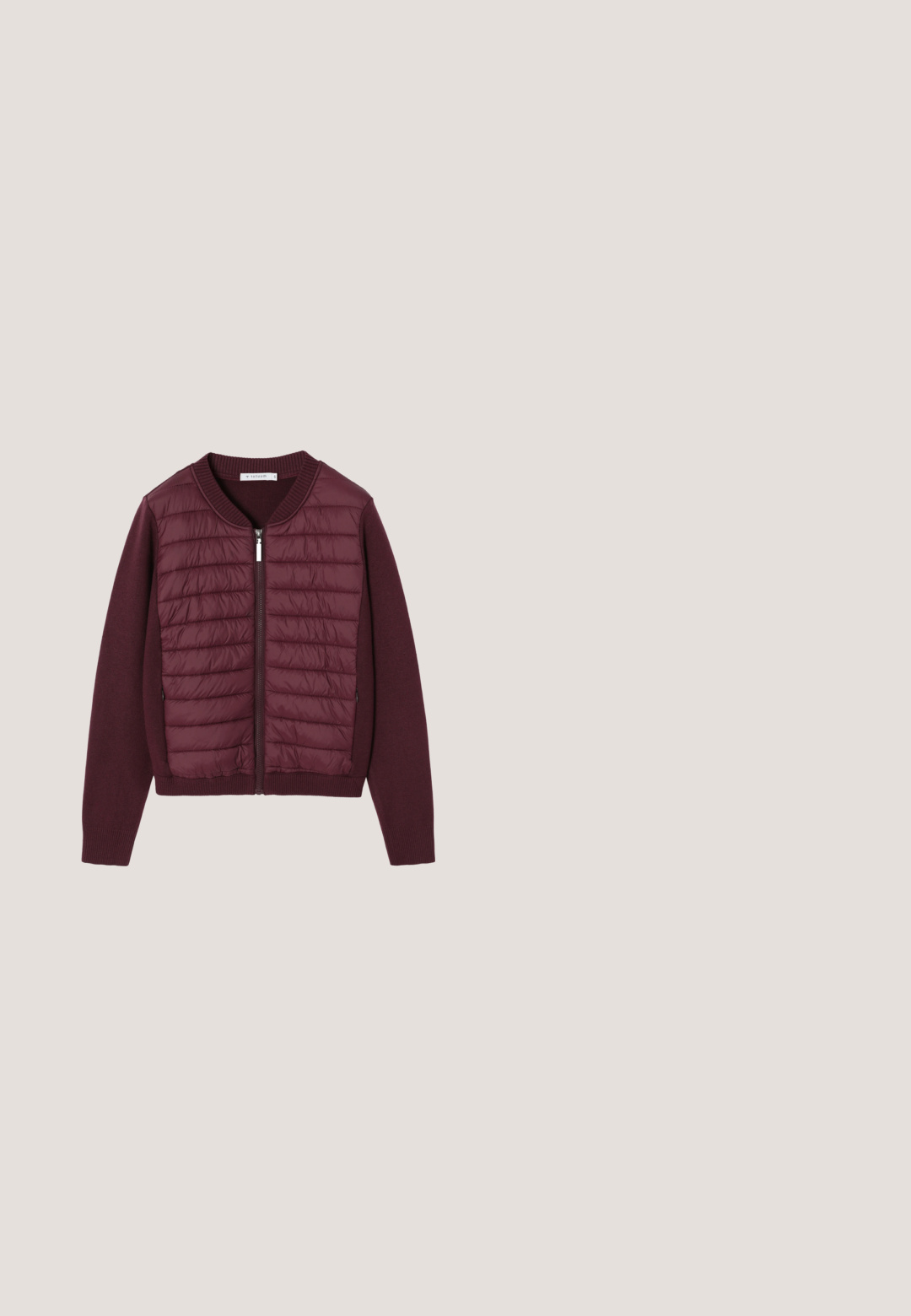 Veste bourgogne avec un devant matelassé, fermeture éclair, et poignets et ourlet en tricot côtelé. Texture douce, rembourrage léger et coupe décontractée.; T-shirt blanc à manches courtes en coton doux, avec un col arrondi et une étiquette avec "NEXT" au dos intérieur.; Jupe en denim avec une silhouette droite, présentant un délavage bleu moyen, deux grandes poches avant et des coutures visibles le long des coutures.; Baskets en cuir crème avec lacets marron, bout rond, panneau texturé et détail de logo en relief. Semelle blanche avec branding discret.; Sac cabas en cuir marron foncé avec deux longues anses et des boucles dorées sur fond blanc.; Bague en or avec une pierre verte en forme de trèfle à quatre feuilles, sertie dans un chaton lisse, photographiée sur un fond blanc.