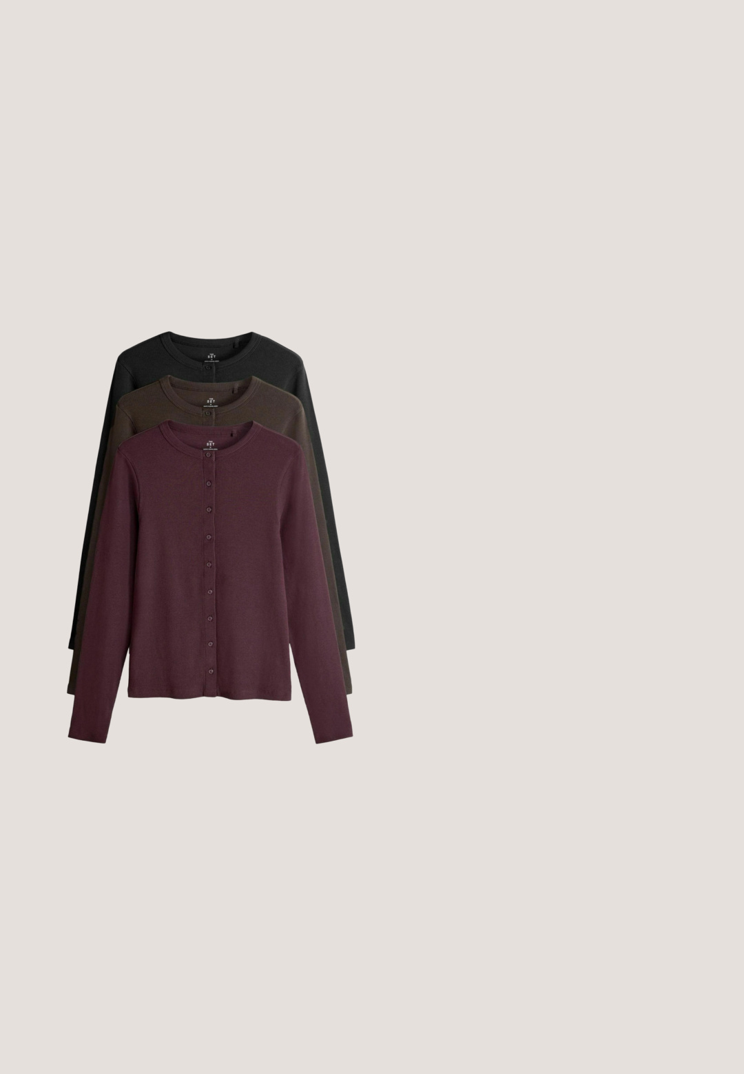 Sæt af tre langærmede cardigans i maroon, mørkegrøn og sort. Har en rund halsudskæring og knaplukning foran.; Ærmeløs mørkelilla vest med rund halsudskæring, der har fem sølvknapper foran og et glat, tekstureret stof.; Brun langærmet turtleneck-top lavet af ribbet stof; har en høj, foldet krave og en afslappet pasform med lige kant.; Mørkebrune bukser med elastisk taljebånd, sidelommer og lige, vide ben, der er afkortet over anklerne.; Brun ruskind ankelstøvle med tyk sål og fluffet lammeskindskant omkring åbningen, sidevisning på hvid baggrund.; Brun struktureret tote taske med to skulderremme og sidelommer, vist på en hvid baggrund.