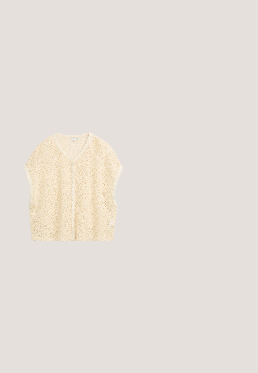 Crèmekleurig mouwloos gehaakt vestje met V-hals en ronde kantpatronen, knoopsluiting aan de voorkant en een losse pasvorm.; Bloemrijke maxi-jurk met een vierkante halslijn, pofmouwen en een getailleerde bovenkant. Heeft een zwarte achtergrond met meerkleurige bloemmotieven.; Tan nubuckle wedge sandaal met een jute touwzool, open teen ontwerp en een gevlochten gaasrug met een striksluiting en decoratieve accenten.; Geweven beige strooien tas met gevlochten groene en zwarte handvatten en een kleurrijke rechthoekige patch aan de voorkant.; Delicate gouden ketting met verstelbare sluiting, met een enkele witte parel hanger gezet in een kleine gouden kast.; Gouden gevlochten leren riem met een metalen gesp, voorzien van een glad leren band en een puntige uiteinde. Textuur van het geweven patroon duidelijk zichtbaar.