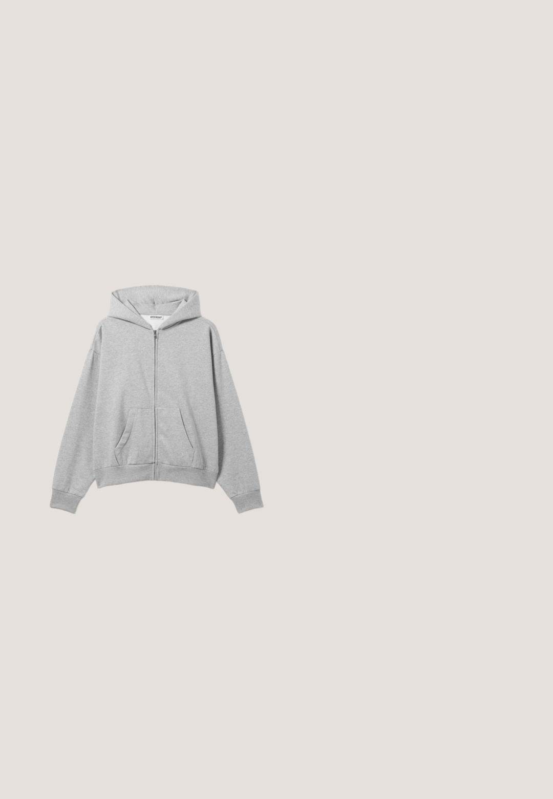 Hellgrauer Kapuzenpullover mit Reißverschluss, Fronttaschen, langen Ärmeln und Kapuze, flach auf einem hellen Hintergrund liegend.; Off-White kurzärmeliges T-Shirt mit einem blau getönten Aufdruck einer Hand, die einen Eistütenkegel vor einem bewölkten Himmel und Ozean-Hintergrund hält.; Hellblaue Jeans mit geradem Bein, Fronttaschen, Gürtelschlaufen, Reißverschluss und einem gebrandeten Knopfverschluss an der Taille.; Olivgrüne Wildleder-Stiefeletten mit schwarzen, robusten Sohlen, ausgestattet mit Schnürdesign und Zugschlaufe an der Ferse, präsentiert auf einer Holzoberfläche.; Rechteckige Sonnenbrille mit blauen Gläsern, dünnen goldfarbenen Metallrahmen und durchscheinenden blauen Bügeln, auf einer neutralen Oberfläche platziert.; Kompakte schwarze zylindrische Kulturtasche mit verstellbarem Riemen und Calvin Klein Logo auf der vorderen Aufnäher.