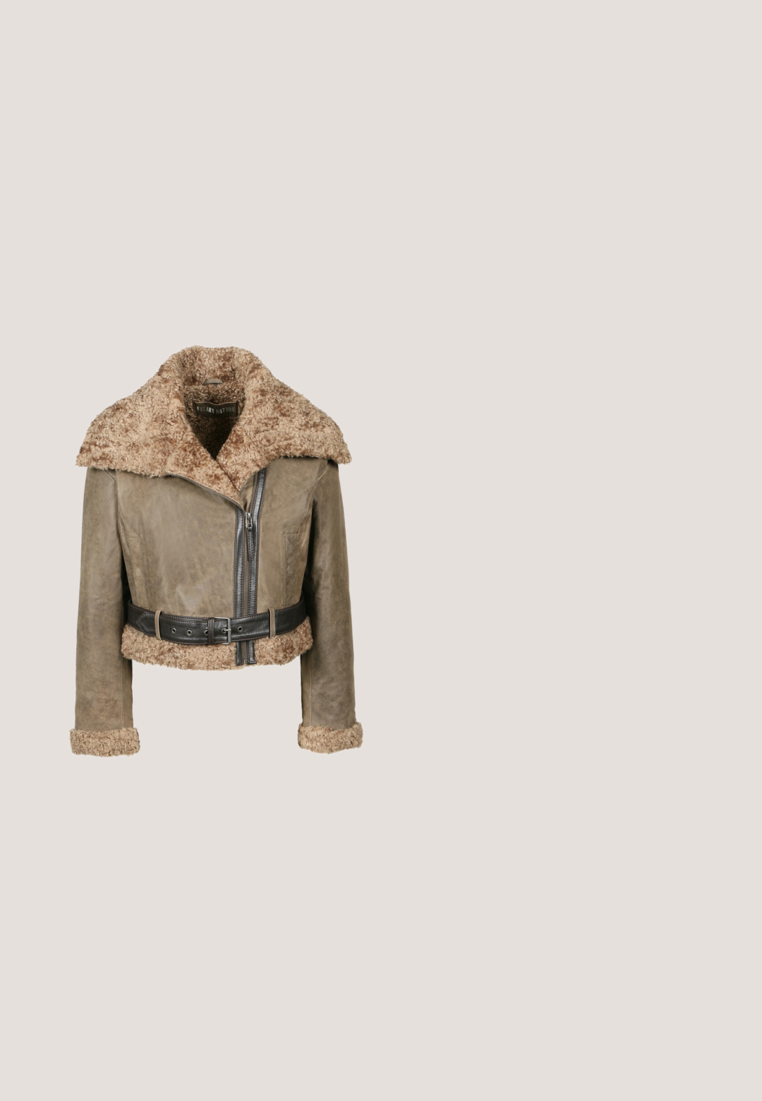 Bruine leren cropped jacket met een donzige tan kraag en manchetten, voorzien van een ritssluiting aan de voorkant en een brede zwarte riem met gespdetails.; Crème trui met lange klokmouwen, voorzien van een versleten design, geborduurde schedel en bloemen op de mouwen, en 'ed hardy' tekst in het rood.; Grijs geribbeld T-shirt met korte mouwen, een ronde hals en een klein knoopdetail aan de voorkant. Bevat een logo op het linkerborstgebied.; Grijze spijkerbroek met flair, voorzien van een vervaagde wassing, vijf-pocket ontwerp en contrasterende gouden hardware. Rechte tailleband met knoopsluiting.; Donkerbruine leren enkellaarzen met een ritssluiting aan de zijkant, decoratieve gouden studs aan de voorkant, riempje met knoop dichtbij de hiel en een stevige gestapelde hak.; Grijze doorgestikte leren handtas met twee handvatten en een metalen merkembleem aan de zijkant versierd met klinknagels en tekst.