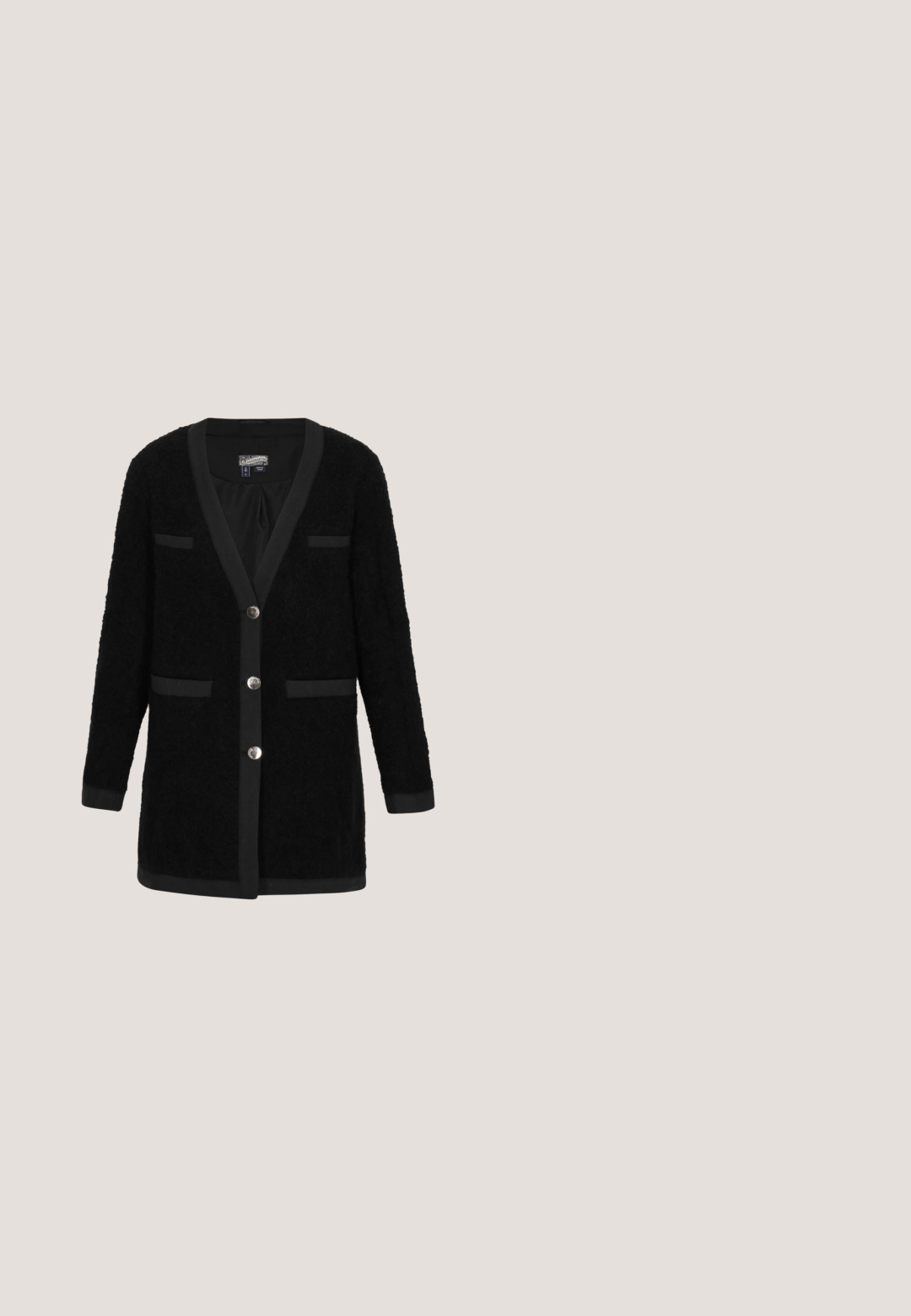 Zwarte cardigan van gestructureerde stof, met een V-hals, lange mouwen, twee zakken met decoratieve afwerking en zilveren knoopsluitingen.; Zwart T-shirt met korte mouwen en V-hals, recht zoom en een zichtbaar wit label aan de binnenkant van de halslijn.; Donkergrijze rechte jeans met omgevouwen pijpen, een knoop en rits aan de voorkant, riemlussen, en voor- en achterzakken.; Zwarte suède platte schoen met een puntige neus, gouden metalen detail op de wreef en een kleine hak. Gladde textuur met een effen kleur.; Zwart gestructureerde leren schoudertas met ritssluiting, smalle handgreep en een lange tassel als ritstrekker op een witte achtergrond.; Gouden ringoorbellen met een gedraaide ontwerp, voorzien van een hangende cirkelvormige hanger met een uitgesneden klavertje vier.