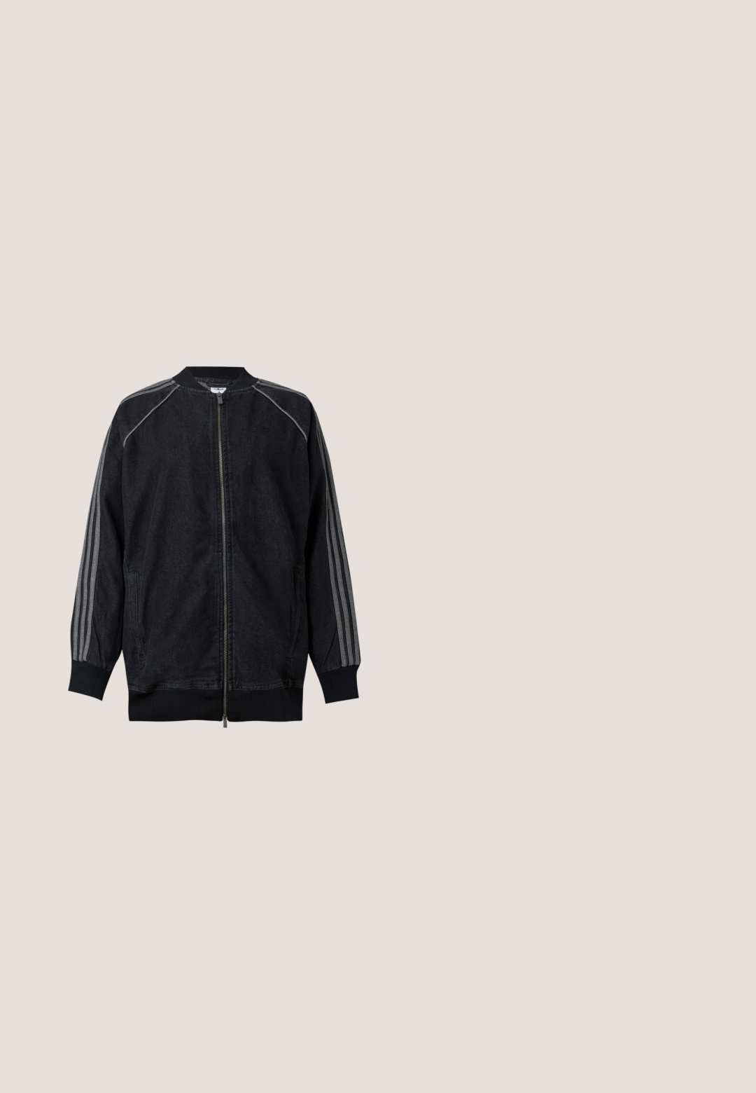 Musta vetoketjullinen takki, jossa ribbineuloskaulus ja -hihansuut, varressa kolme vaaleanharmaata raitaa olkapäästä ranteeseen.; Vaaleanharmaa Adidas lyhythihainen t-paita pyöreällä kaula-aukolla ja pienellä valkoisella Adidas-logolla rinnassa, esitetty yksivärisellä taustalla.; Mustat leveät farkut kolmella valkoisella raidalla jokaisella sivulla ja pienellä valkoisella logolla. Ominaisuuksiin kuuluvat etutaskut ja napitus.; Mustat nahka- ja mokkanahkalenkkarit, joissa on tarranauha, kolme valkoista raitaa ja kumipohja. Sivussa lukee "SAMBA".; Harmaa kangas Adidas olkalaukku mustalla säädettävällä hihnalla ja etutaskulla, jossa on Adidas-logo.; Pari kiiltäviä hopeisia renkaanmuotoisia korvakoruja, joissa on ohuet langan sulkimet, esillä vaaleanharmaalla taustalla.