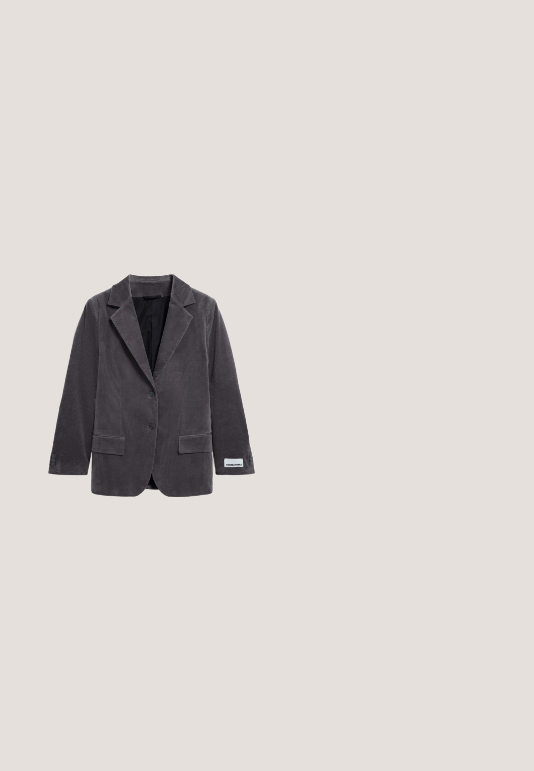 Blazer de pana gris con solapa de muesca, dos bolsillos frontales, cierre de un botón y etiqueta en la manga. Tejido texturizado y corte entallado.; Poncho de lana gris oscuro con mangas anchas y cuello redondo, mostrado sobre un fondo blanco.; Suéter de punto gris de manga corta con escote redondo, que presenta una textura suave y un corte holgado, mostrando un color uniforme en todo su diseño.; Pantalones grises texturizados con cierre de botón, cremallera y ganchos adicionales, con detalles plateados en la cintura y el forro interior.; Zapatillas de ante en marrón oscuro con cordones crema, diseño de bajo perfil, puntera redondeada y costuras en contraste a lo largo de los lados y el talón.; Bolso de hombro grande de ante gris oscuro con una sola correa y estructura suave y caída, mostrado sobre un fondo blanco.