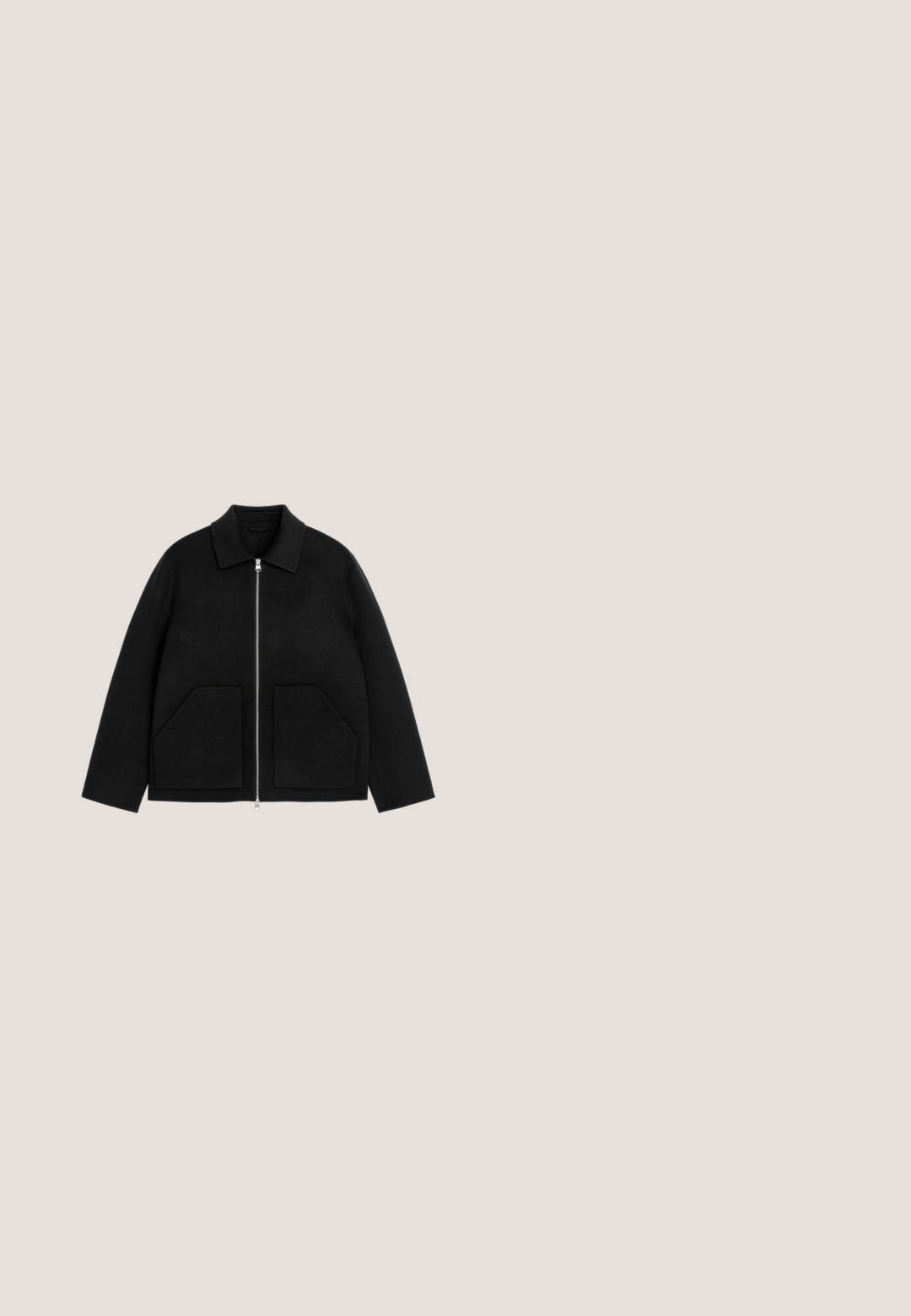 Chaqueta negra con cuello doblado, cierre frontal con cremallera y dos grandes bolsillos delanteros sobre un fondo blanco.; Suéter negro de punto acanalado con mangas largas y escote redondo. Presenta una tela texturizada y un corte relajado. Sin herrajes ni acentos visibles.; Camiseta negra de algodón de manga corta y cuello redondo, colocada plana sobre un fondo blanco.; Chinos negros fabricados con un suave tejido de algodón. Cuentan con un cierre de botón, bolsillos frontales y un diseño de pierna recta con bordes limpios.; Botín Chelsea de cuero negro con panel lateral elástico, tirador en el talón, puntera redonda y suela de goma gruesa.; Bolsa de aseo rectangular de cuero negro con cremallera y nombre de marca en relieve en la parte frontal, sobre un fondo blanco liso.