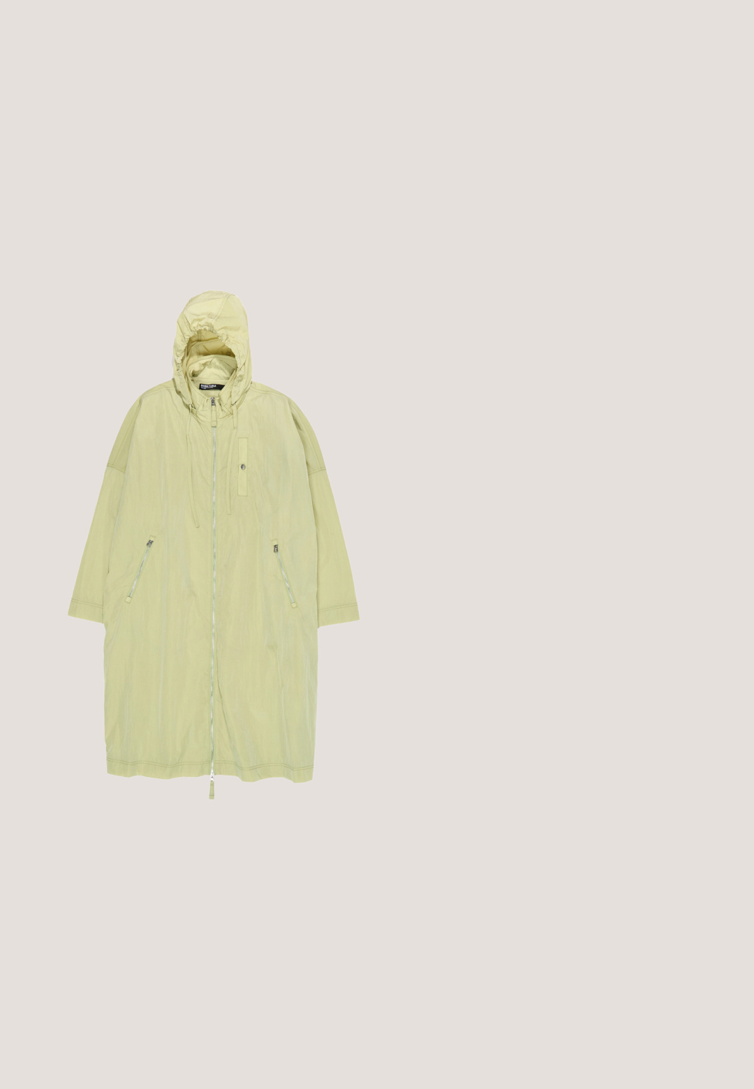 Pitkä vaaleanbeige hupullinen takki, jossa edessä vetoketju, kaksi sivutaskua vetoketjulla ja säädettävät hupun nyörit.; Hihaton oliivinvihreä jumpsuit kuminauhalla kerrostettu yläosa, röyhelöllä vyötärö, solmittavat olkahihnat, löysät housut ja joustavat nilkkaremmit.; Vihreät matalat kengät, joissa on virtaviivainen muotoilu, oranssi reunus ja pehmeä tekstuuri. Ominaisuuksiin kuuluu pyöristetty varvas ja joustava pohja.; Suorakaiteen muotoiset vihreät asetaatti-aurinkolasit, joissa on tummennetut linssit ja pienet kullanväriset yksityiskohdat etukulmissa ja sankoissa.; Pehmeä oliivinvihreä pieni käsilaukku säädettävällä kudotulla olkahihnalla ja rypytetyllä, pyöreällä kangasmuodilla yksiväristä taustaa vasten.; Kultainen lukko-rannekoru, jossa vuorottelevat valkoiset helmet, siniset neliönmuotoiset helmet, vihreät sylinterimäiset helmet ja pienet kultaiset pyöreät helmet valkoisella taustalla.