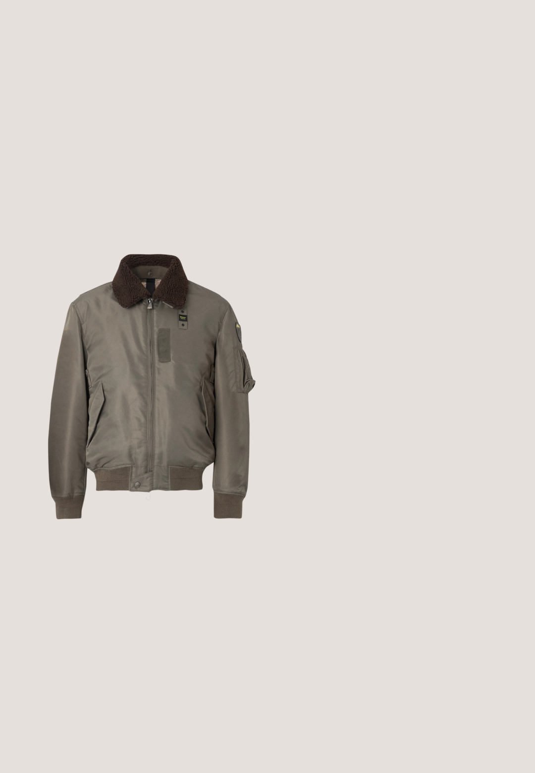 Brauner Kragen-Bomberjacke in Olivgrün mit Reißverschluss vorne, Seitentaschen und gerippten Bündchen und Saum. Das Material wirkt glatt mit einer matten Oberfläche.; Schwarzer Pullover mit einem Reißverschlusskragen, langen Ärmeln, gerippten Bündchen und Saum, aus einem weichen, glatten Stoff hergestellt.; Blaue Jeans aus Denim mit entspannter Passform, geraden Beinen, sichtbarem Nähen und einem vorderen Knopfverschluss. Verfügt über eine Seitentasche mit einem Akzent.; Braune Wildleder-Stiefeletten mit runder Zehenpartie, Schnürung vorne, metallenen Ösen und einer robusten schwarzen Gummisohle mit Profil.; Kleine beige Umhängetasche mit vorderer Reißverschlusstasche, metallischem ALDO-Logo, verstellbarem breitem Riemen und abgerundeter rechteckiger Form vor weißem Hintergrund.; Silberne Kettenhalskette mit einem rechteckigen Anhänger mit strukturierten Linien. Anhänger ist mit einer Schlaufe befestigt; die Kette hat ein glattes, flexibles Design.