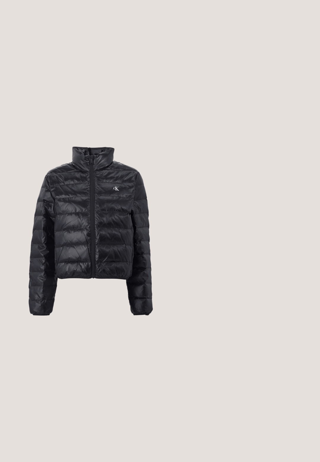 Chaqueta puffer negra hecha de un material brillante y ligero, con un diseño recortado, cuello alto y cierre de cremallera. Presenta un patrón acolchado y un logo.; Camiseta negra con detalles en blanco, que presenta un gráfico audaz de Calvin Klein 1968 en el centro. Fabricada en algodón, de manga corta.; Jeans de mezclilla negros de tiro alto con piernas rectas, diseño de cinco bolsillos, cierre frontal con botón y detalles de costura mínimos.; Bota Chelsea de cuero negro con paneles laterales elásticos, acabado texturizado y suela rugosa, posicionada sobre baldosas de madera marrón con guijarros.; Bolso de mano de cuero blanco con forma curvada, con un logo "CK" en relieve en la parte delantera y una sola correa para el hombro. Cierre de cremallera en la parte superior.; Calvin Klein SPIRAL - Pulsera - silver-coloured