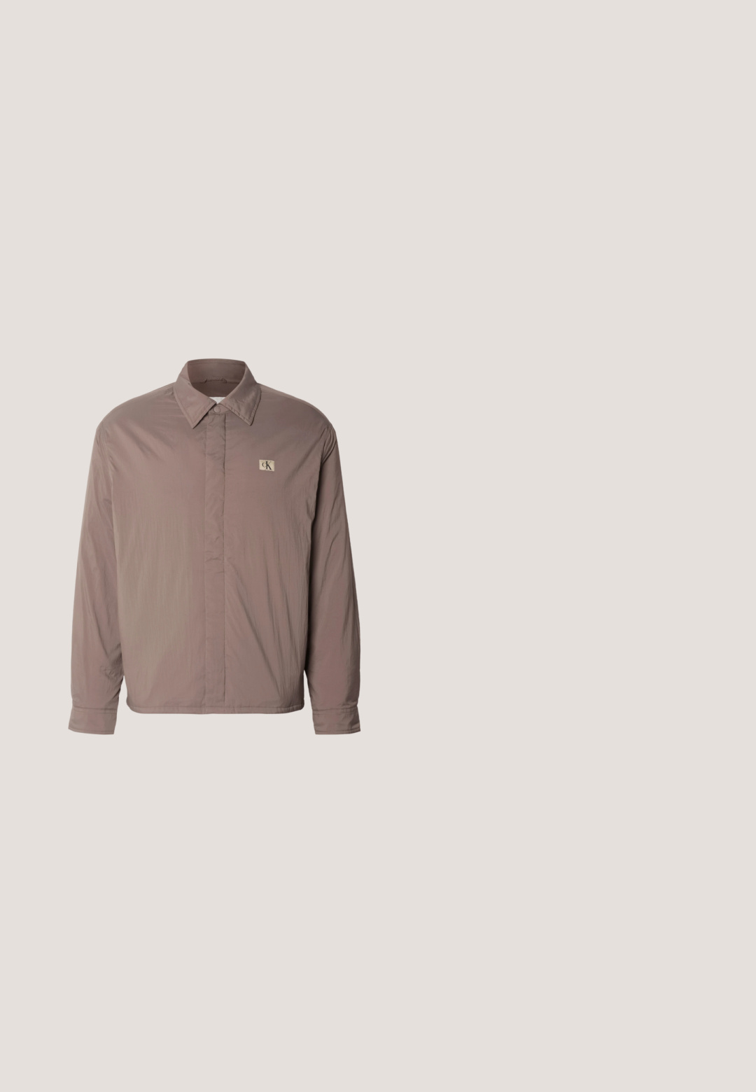 Camisa de manga larga ligera en taupe apagado, con cuello abotonado y un pequeño logo beige en el lado izquierdo del pecho. Textura suave.; Sweater de punto morado con mangas largas, cuello redondo, dobladillo y puños acanalados, que presenta un pequeño logo de CK en el pecho. Textura suave.; Polo de rayas marrón y amarillo, de mangas cortas, con tapeta de tres botones, material de algodón, tejido texturizado con diferentes anchos de rayas.; Jeans de mezclilla azul oscuro con un diseño de pierna recta, que presentan un desgaste sutil, un cierre de botón y un estilo clásico de cinco bolsillos.; Botas de cuero marrón hasta el tobillo con punta redonda, detalle de cordones y suela de goma negra. Logo notable en el talón y acentos de costura.; Bolso bandolera de nylon negro con textura y forma rectangular, que cuenta con un bolsillo delantero con cremallera y una placa metálica con el logo. Incluye una correa ajustable.