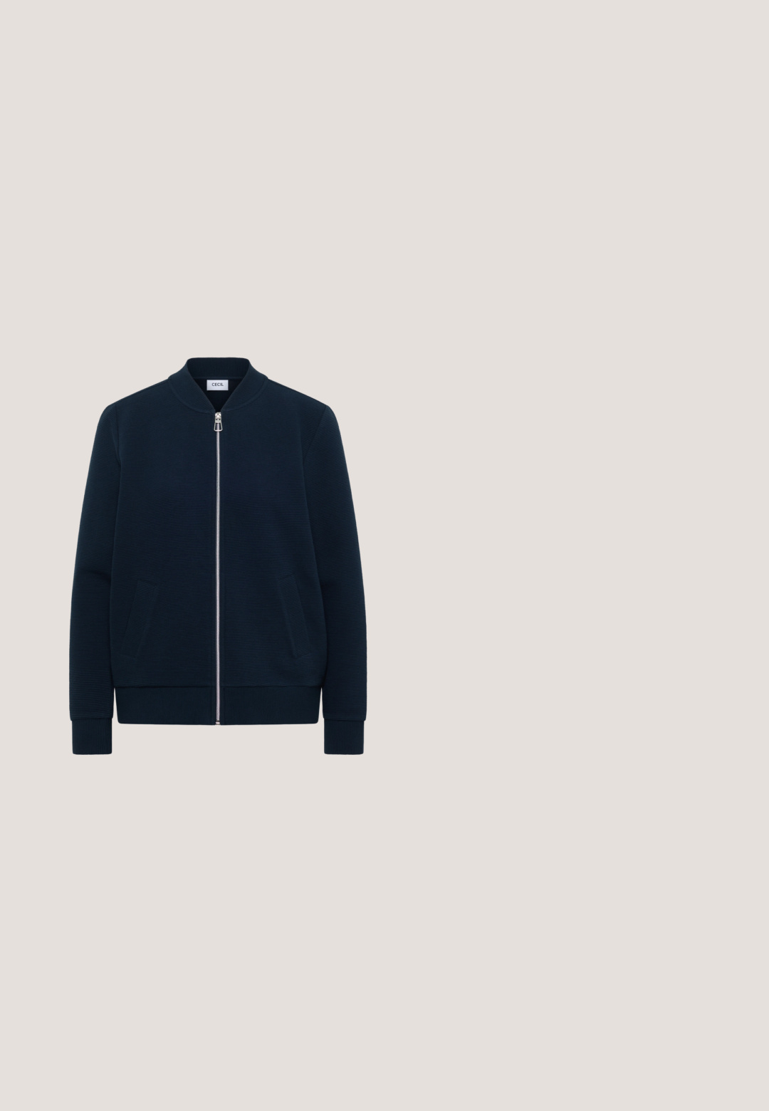 Veste zippée côtelée bleu marine avec col montant, manches longues, deux poches avant et fermeture éclair argentée, étiquetée "Cecil".; Haut court sans manches rose pâle avec encolure ronde et fermeture par boutons au dos, fabriqué en tissu texturé.; Culottes en denim bleu clair avec taille haute, jambes larges, et design à cinq poches avec des coutures contrastantes et une fermeture à bouton.; Baskets blanches basses avec semelle épaisse beige à rainures prononcées et découpe en forme de cœur près du talon sur le côté.; Petit sac à main en forme de croissant avec corps en tissu beige, garniture en cuir marron, poignée tressée et accents dorés pour le logo et la chaîne.; Le bracelet doré présente des maillons rectangulaires, un fermoir mousqueton, et une extension de chaîne avec une étiquette affichant le nom de la marque 'Guess'.