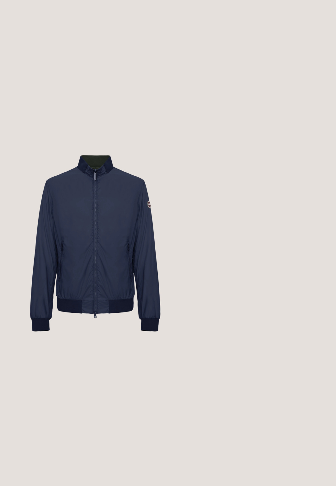 Chaqueta ligera azul marino con cremallera frontal, cuello alto, puños y dobladillo acanalados, y un pequeño logo redondo en la manga izquierda.; Sudadera de color azul marino con cremallera, cuello alto, puños y dobladillo de canalé; presenta un pequeño logo bordado en el pecho. Textura de tela suave.; Camiseta de manga corta azul marino con cuello redondo y bolsillo en el pecho que presenta un pequeño logo bordado de corona de laurel.; Pantalones deportivos azul marino con cinturilla elástica y puños, bolsillos laterales, cordón ajustable y pequeño logo en el muslo izquierdo.; Zapatilla azul oscuro de cuero liso, con punta redondeada, suela de goma blanca y detalles del logo en el lateral. Ojetes plateados para los cordones.; Bolsa deportiva azul marino y blanca con doble asa, una correa para el hombro y un logotipo frontal que dice "Worldwide Sportswear Classic Varsity Aesthetic".