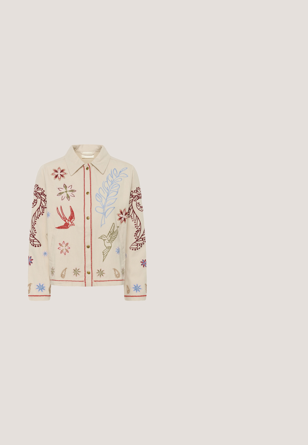 Beige jas met rode, blauwe en groene bloemen- en vogelborduursels, knoopsluiting, kraag en lange mouwen met decoratieve patronen.; Bloes met bloemmotief in lichtgroen met roze en witte accenten, met een geraffineerde lijf en pofmouwen, die aan de achterkant is vastgebonden met franjes.; Bruine corduroy broek met een wijd beenontwerp, met verticale ribbels en een tailleband. De stof heeft een zachte, gestructureerde uitstraling.; Bruine leren loafer met dikke zwarte profielzool en gestikte details op een neutrale achtergrond.; Vierkante zijden sjaal met roze en gouden randen, voorzien van bloem- en vlinderpatronen in zachte pasteltinten.; Bruine suède crossbody tas met een handvat aan de bovenkant, een klep aan de voorkant en goudkleurige hardware. Bevat een leren accent aan de basis van de klep.