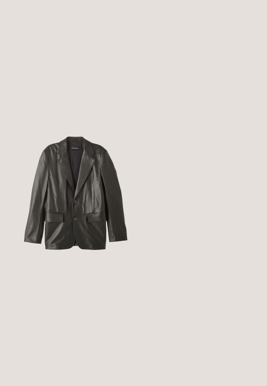Sort læderblazer med klapkraver, to knapper og klaplommer, lagt fladt mod en hvid baggrund.; Hvid skjorte med knapper og tekstureret stof, foldet pænt. Indersiden af kraven har et grønt mønster med guldcirkler. Mærkeetiketten er synlig.; Grå skræddersyede bukser med fordele, sidelommer, knaplukning, bæltestropper og opsmøgede kanter, vist på en hvid baggrund.; Sort læderloafer med en glat finish, en dekorativ rem over vristen, rund tå og en lav stablet hæl.; Sorth læder crossover taske med en tekstureret overflade, der har en frontlomme med lynlås, justerbar strop og metal hardware detaljer.; Sorte læderbælte med en sølv rektangulær spænde og præget logo detalje. Flad design med en glat tekstur og klassisk finish.