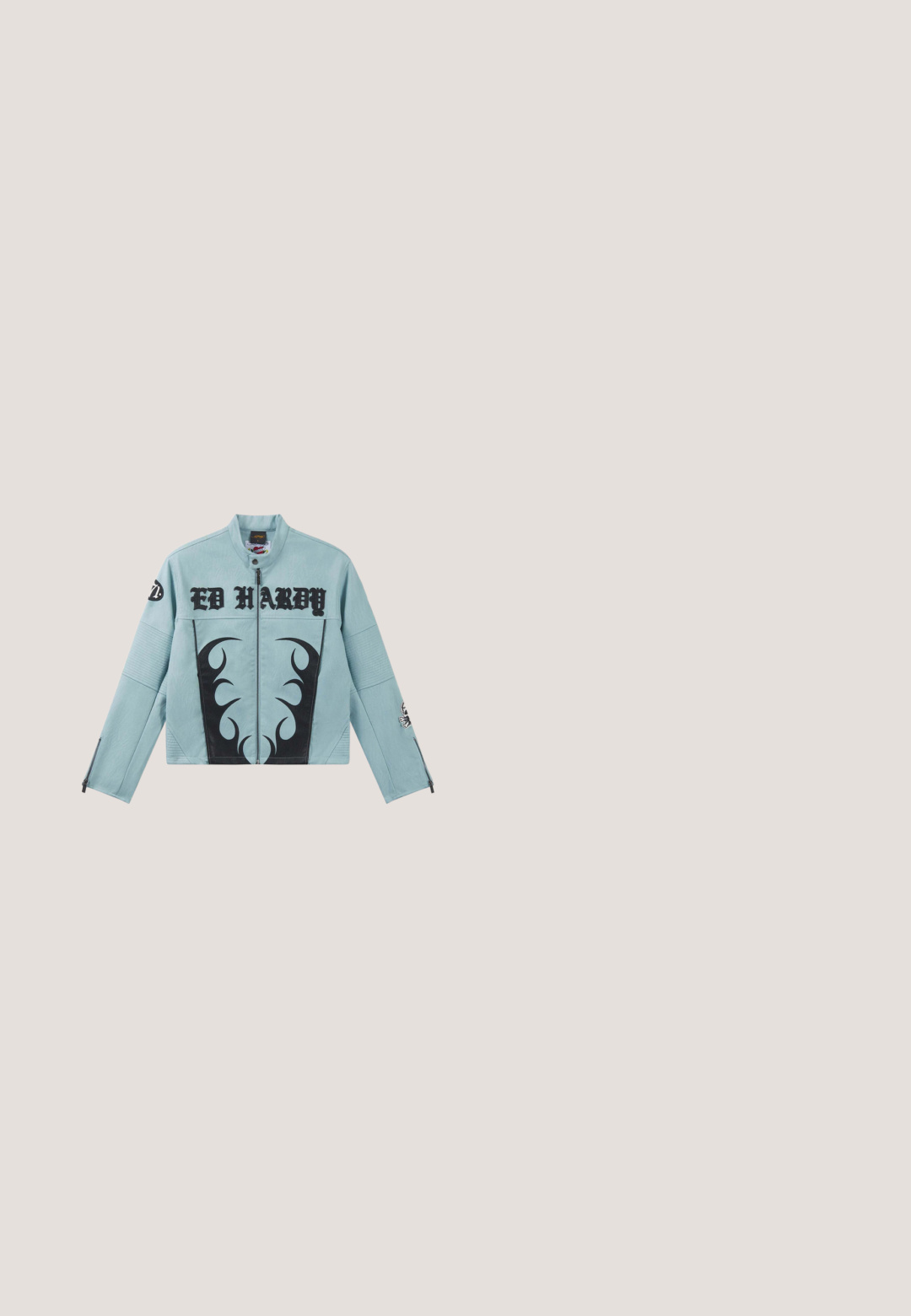 Veste Ed Hardy bleu clair avec motifs de flammes noirs à l'avant, texte du logo sur la poitrine, manches zippées et écussons sur les bras.; T-shirt noir raccourci en mélange de coton. Présente des manches courtes et un col rond avec une texture lisse et sans motifs ni accents visibles.; Jeans larges bleu clair en denim, avec taille haute, design à cinq poches et couture visible le long des coutures.; Baskets montantes en denim texturé de couleur bleu foncé avec une semelle en caoutchouc blanche épaisse. Présentent des lacets noirs et un talon accentué par un logo.; Sac à épaule en denim bleu foncé avec des appliqués floraux, boucle en argent et logo "Desigual" à l'avant, bandoulière réglable.; Pendentif en métal argenté en forme de lettre "M", avec un design ondulé et une finition brillante, et une petite boucle pour attacher.