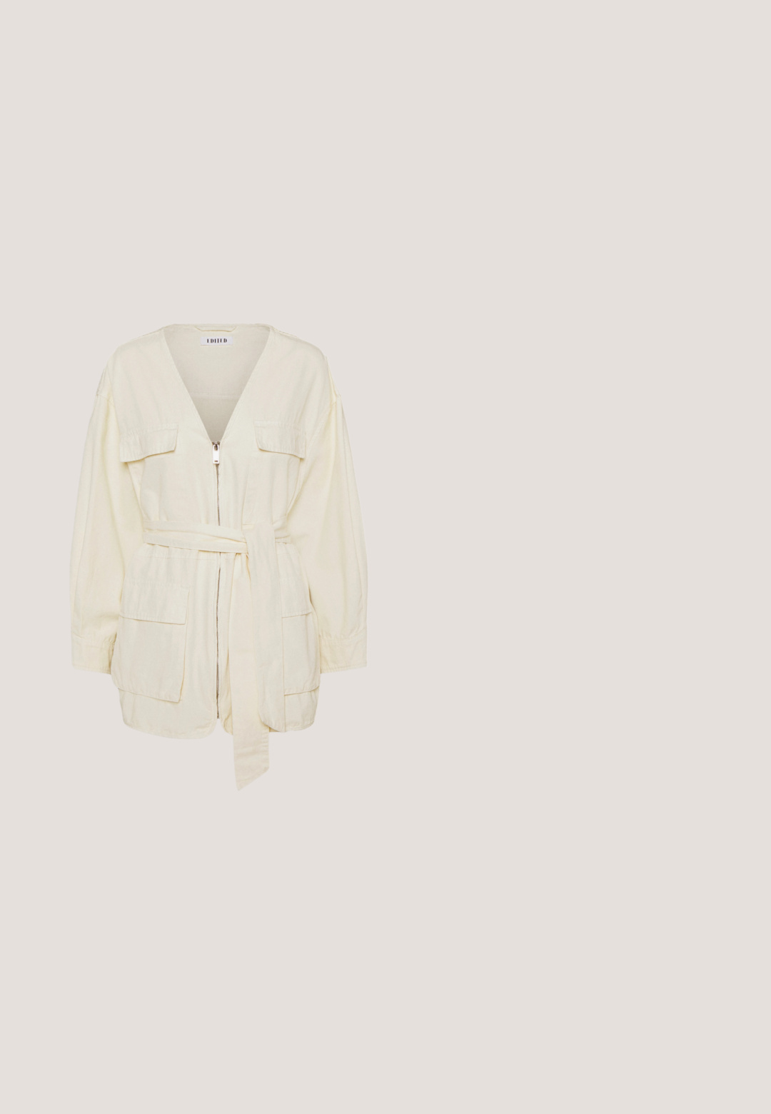 Veste en coton crème avec des manches longues, un col en V, fermeture éclair à l'avant, deux poches plaquées et une taille nouée. Texture lisse, coupe décontractée.; Pull long à manches longues en beige clair, fabriqué dans un tissu extensible. Présente un col rond et une silhouette ajustée avec des poignets resserrés.; Jean en denim bleu classique avec une coupe slim droite, cinq poches, fermeture éclair et une texture légèrement décolorée pour un look décontracté.; Baskets blanches avec un logo V noir, présentant un dessus en cuir lisse, un bout rond, un système de laçage et un empiècement au talon noir contrastant.; Lunettes de soleil rondes avec des montures en métal doré et des verres vert foncé. Les branches présentent un design écaille de tortue pour un détail supplémentaire.; Boucles d'oreilles en or, en forme de créoles, présentant deux cercles entrelacés avec un fini texturé. Conçues avec un arrière lisse et sécurisé.
