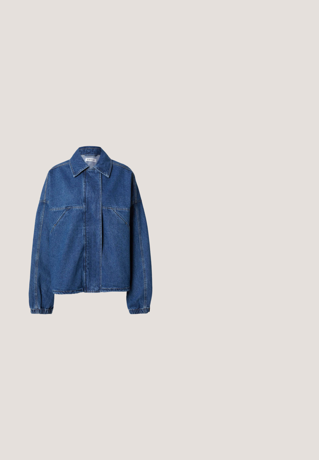 Veste en denim bleu avec un col pointu, une fermeture frontale cachée, des poches poitrine inclinées, des manches longues et des poignets élastiqués.; Pull noir à manches longues avec col rond, col, poignets et ourlet côtelés, fabriqué en tissu doux et texturé.; Pantalons à jambes larges en tissu bleu marine. Dispose d'une taille élastique, de poches avant et d'une texture lisse. Design ajusté avec un minimum de coutures.; Chaussure en cuir marron foncé à talon haut flottant au-dessus d'un sol réfléchissant près d'une étagère métallique avec des panneaux blancs dans une pièce.; Sac à main semi-circulaire jaune avec deux poignées, une fermeture éclair, et un porte-clés en forme de cœur avec une petite étiquette et un charm en forme de lettre "G".; Deux colliers en or à deux couches avec de petites perles colorées espacées uniformément le long de chaînes délicates et une étiquette à fermoir ronde.