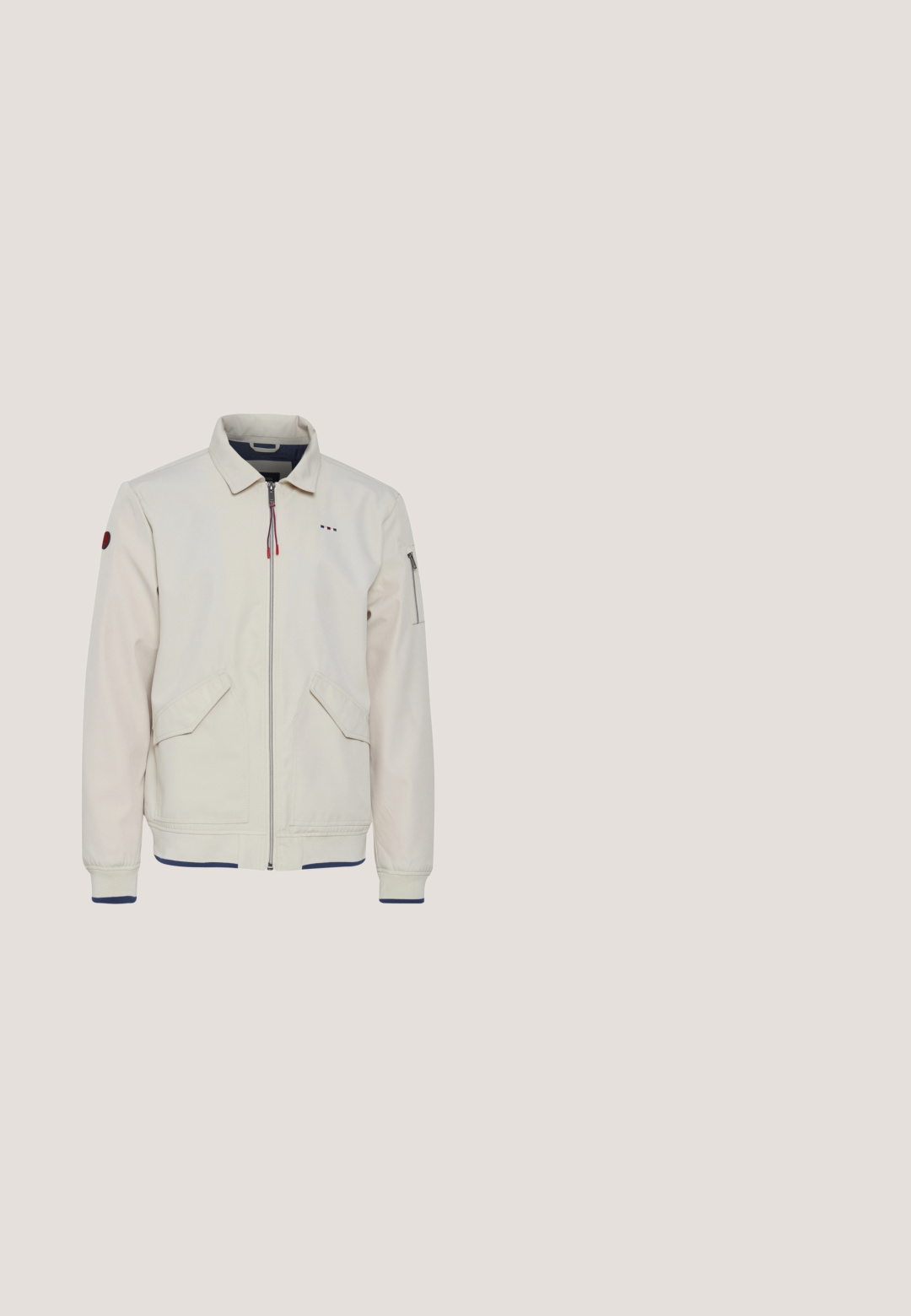 Lys beige jakke med krave, frontlynlås, to sidelommer og en ekstra lynlåslomme på ærmet. Ribbet kant og manchetter.; Grå T-shirt med korte ærmer med hvid Puma-tekst og sort puma-katlogo foran, ensfarvet baggrund.; Marineblå bomuldsshorts med elastisk talje, der har en glat tekstur og stikninger i falden. Lille logo på siden.; Sorte læder ankelstøvle med grå stikninger, gummisål, rund tå, snørredesign og en polstret krave med Fila-logo.; Sorte rektangulære solbriller med mørke tonede linser og tykke stel, hvilende skråt på en ensfarvet lys grå overflade.; Sort crossbody taske med lynlåslomme foran og justerbar rem med teksten "KARL LAGERFELD JEANS" i hvide bogstaver.
