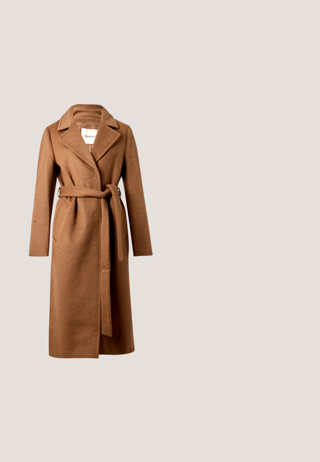 Lange bruine wollen jas met brede revers, twee zijzakken en een gestrikte riem in de taille, weergegeven tegen een effen achtergrond.; Beige gebreide trui met een losse pasvorm, brede botte halslijn en ribgebreide manchetten. Zachte textuur met een subtiel horizontaal patroon overal.; Grijze wijde pantalon met een geplooid front, gemaakt van een gladde stof. Heeft een platte tailleband met riemlussen en zijzakken.; Zwarte leren enkelboot met een spitse neus, gladde textuur, minimalistisch ontwerp en een lage blokhak. Zijrits gaat tot de enkel.; Beige wollen sjaal met franjes aan de uiteinden en een klein wit label dicht bij één rand, plat weergegeven op een witte achtergrond.; Bruine leren totebag met een gestructureerd ontwerp, voorzien van dubbele handvatten aan de bovenkant en zichtbare stikselaccenten, gecombineerd met een witte top met lange mouwen en beige shorts.