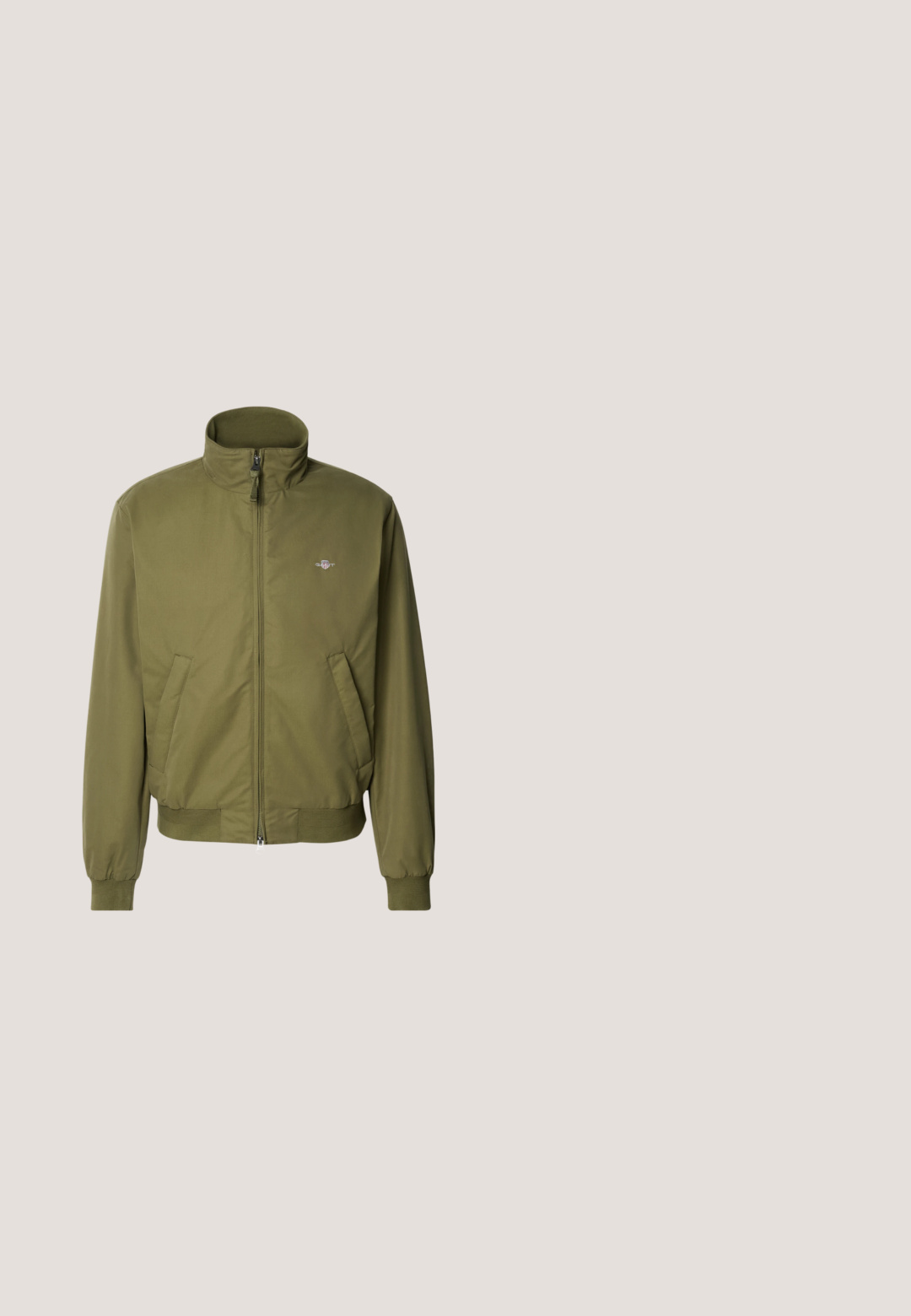 GANT HAMPSHIRE JACKET - Chaqueta fina - moss green; Sudadera verde oscuro con cuello redondo, mangas largas y emblema circular que dice "GANT 1949 New Haven Connecticut" con un escudo de estrellas y rayas.; Camiseta de algodón color crema con cuello redondo, mangas cortas y un pequeño estampado en navy en el pecho que dice "GANT 32 EAST 39TH ST. NEW YORK."; Pantalones de algodón verde oliva con diseño de pierna recta, cierre de botón visible y costuras en las rodillas para añadir detalles y estructura.; Botín Chelsea de cuero marrón con un acabado texturizado, paneles laterales elásticos y una lengüeta. Presenta una suela de goma para proporcionar tracción.; Neceser rectangular de color verde oliva con una correa horizontal negra y parche con el logo de Calvin Klein en el frente, cierre de cremallera en la parte superior.