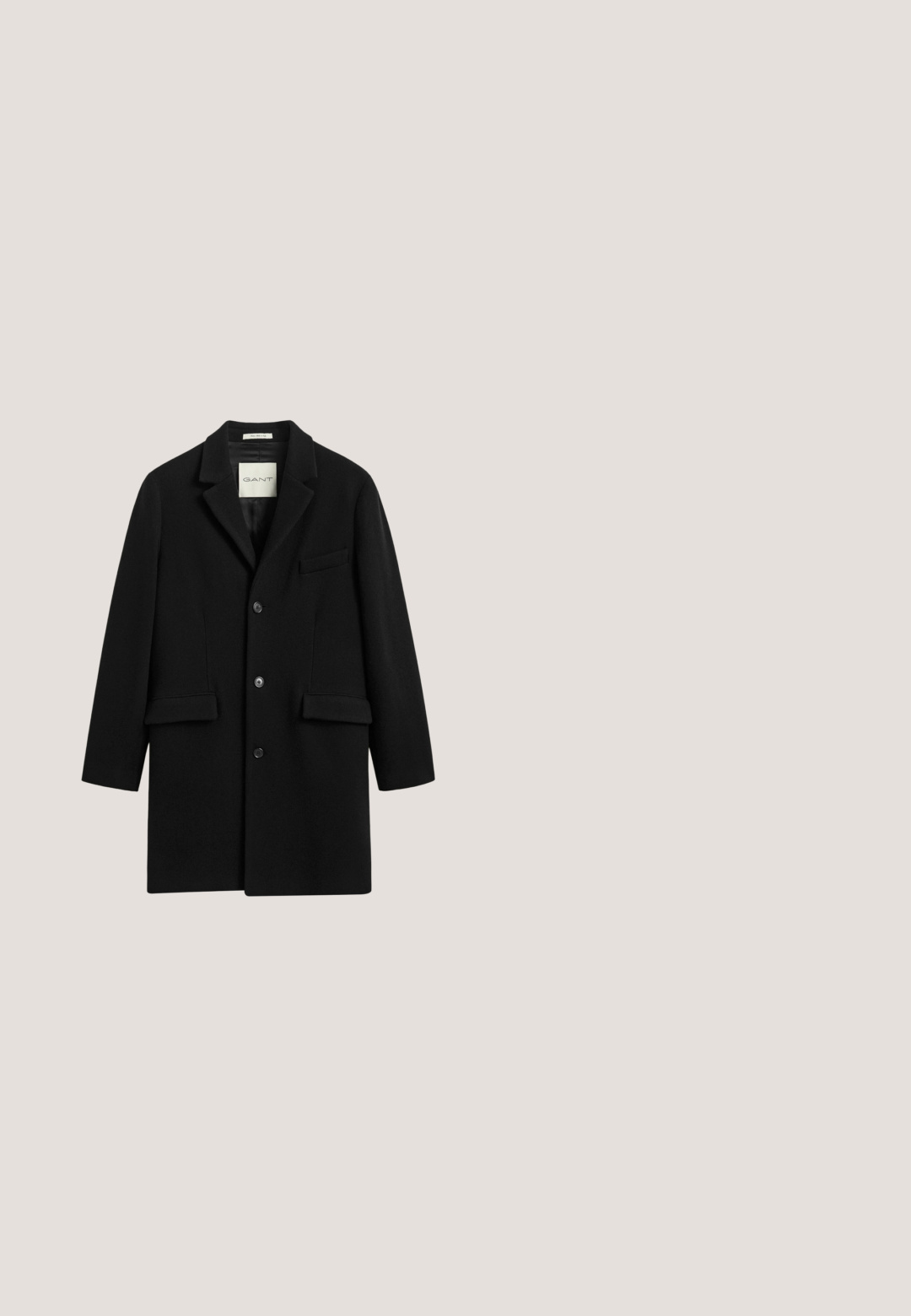Sort uld herrefrakke med tre knapper, revers med hak og to forlommer med klap.; Sort crew-neck sweater lavet af et glat strikket stof. Har lange ærmer samt ribbede manchetter og kant. Simpelt, ensfarvet design uden mønstre.; Next EASY CARE REGULAR FIT DOUBLE CUFF - Skjorter - black; Sorte bukser lavet af glat stof, med en skræddersyet pasform, lige ben og standard forlommer. Ingen synlige mønstre eller accenter.; Sort læder dobbel monk strap finere sko med brun sål og brogue-detaljer, vist fra venstre side.; Sort rektangulær læder toilettaske med forreste lynlåslomme og sidelæder håndtag mod hvid baggrund.