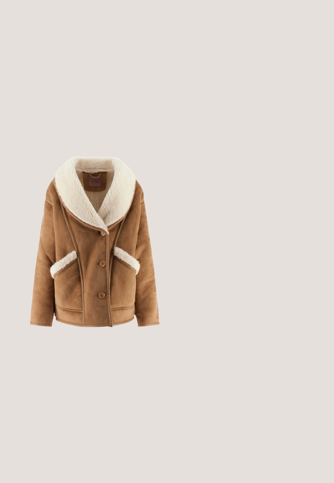 Veste en suédine marron avec un large col en fausse fourrure crème, trois boutons sur le devant et deux poches latérales avec finition en fausse fourrure.; Pull en tricot beige avec lettres en torsade "AS" à l'avant, manches longues, poignets et bas côtelés.; Pantalon évasé en denim bleu foncé avec poches à rabat à l'avant, fermées par des boutons en métal et coutures visibles contrastées.; Botte mi-mollet en daim marron avec bout pointu, petit talon empilé bas et petit détail de logo doré près du talon.; Sac à main marron Liu Jo avec doubles anses, ferrures dorées et détails en cuir, avec un design à cordon et un pendentif logo suspendu à l’avant.; Anneau en or avec un visage rond présentant un "G" central entouré de deux rangées de petites pierres précieuses transparentes.