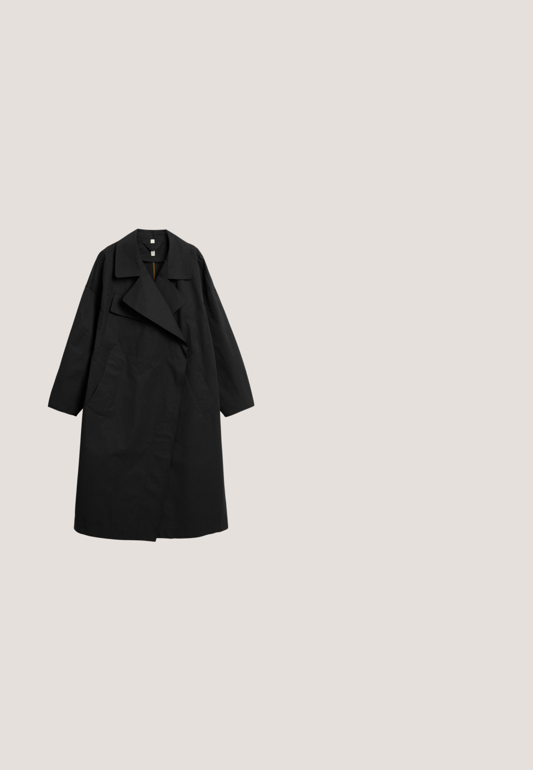 Schwarzer langer übergroßer Trenchcoat mit weitem Reverskragen, langen Ärmeln und zwei vorderen Taschen, flach auf weißem Hintergrund präsentiert.; Schwarzes T-Shirt aus Baumwolle mit Rundhalsausschnitt und kurzen Ärmeln. Zentrale weiße Schrift mit "UNITED COLORS OF BENETTON."; Dunkelgrüne Hosen mit weitem Bein, elastischem Bund und weißen Seitenstreifen entlang der Außennähte jedes Beines.; Schwarze Leder-Ankle-Boots mit strukturierten Oberflächen, runder Zehenpartie, Schnürdesign, gelben Nähten und einer dicken, gerippten schwarzen Plateausohle.; Schwarze Leder-Schultertasche mit einem einzelnen Riemen und kleinem goldenem Logo in der Mitte nahe dem unteren Rand, vor weißem Hintergrund.; Goldarmband mit zwei rechteckigen schwarzen Steinen, verziert mit kleinen Akzentsteinen an einer Seite, glatte Metalloberfläche.