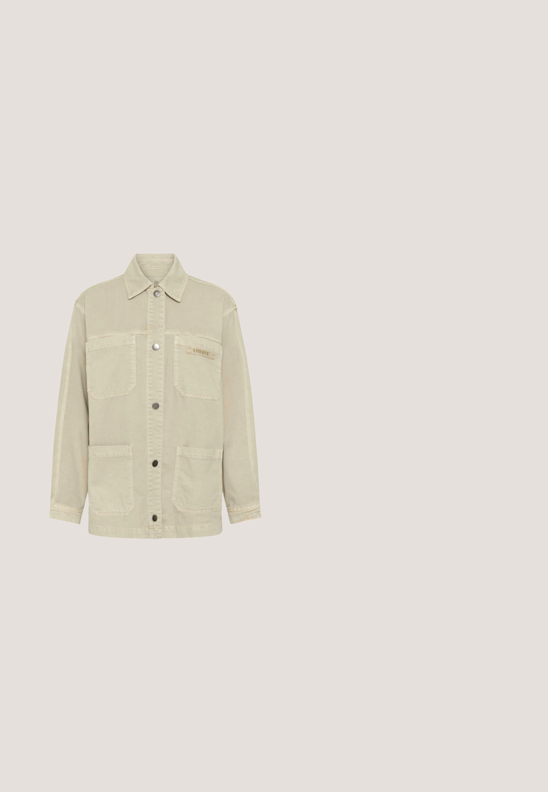 Veste beige à boutons avec quatre poches à rabat, manches longues et col ; petite étiquette "LIBERTE" sur la poche supérieure droite.; T-shirt court beige à manches courtes avec un col rond et une texture subtilement scintillante sur fond blanc.; Jupe en coton beige avec une taille à cordon, deux poches latérales, coupe droite et fentes sur les côtés pour plus de liberté de mouvement. Texture lisse.; Baskets beige et blanc cassé avec fermeture à lacets, panneau latéral en tissu texturé, accents en daim et semelle en caoutchouc marron.; Sac à épaule en cuir vert foncé en forme de demi-lune avec une bandoulière réglable, une fermeture éclair argentée et le logo "Lancaster Paris" sur le devant.; Paire de boucles d’oreilles clous demi-anneaux en or poli avec fermoirs à poussoir sur fond blanc.
