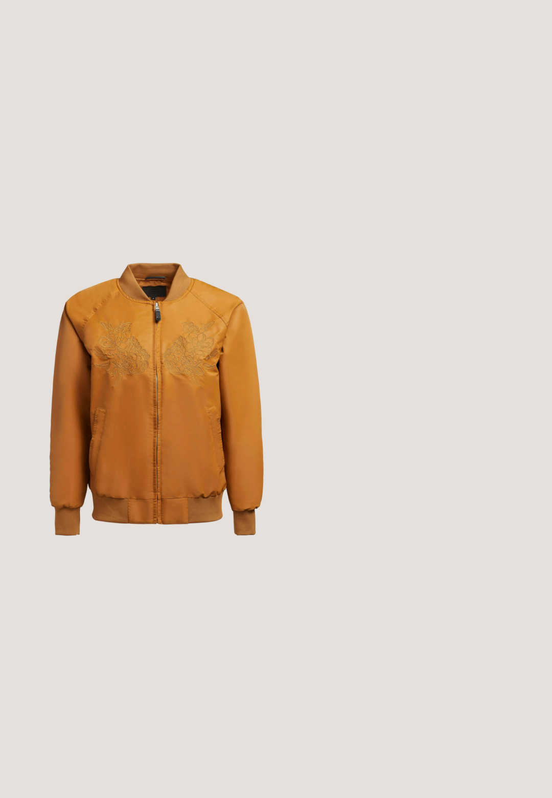 Chaqueta bomber naranja con bordado floral en el pecho, cierre frontal con cremallera, puños acanalados y cinturilla texturizada. Tejido suave.; Camiseta sin mangas acanalada en naranja terracota con cuello redondo y etiqueta visible de AllSaints talla pequeña en el interior del cuello.; Shorts marrones de talle alto hechos de tela elástica, con una textura suave y un diseño ajustado, con un dobladillo limpio y minimalista.; Zapatilla con patrón marrón y cordones blancos flotando sobre un bloque de madera y un suelo de guijarros, con follaje verde y una pared de concreto al fondo.; Bolso rectangular de ante color cuero con correa de hombro ajustable y logo en escritura dorada "Karl" en la solapa frontal.; Pendientes colgantes en tono dorado con un charm texturizado en forma de rombo y un adorno cuadrado liso, suspendidos de una cadena enlazada.