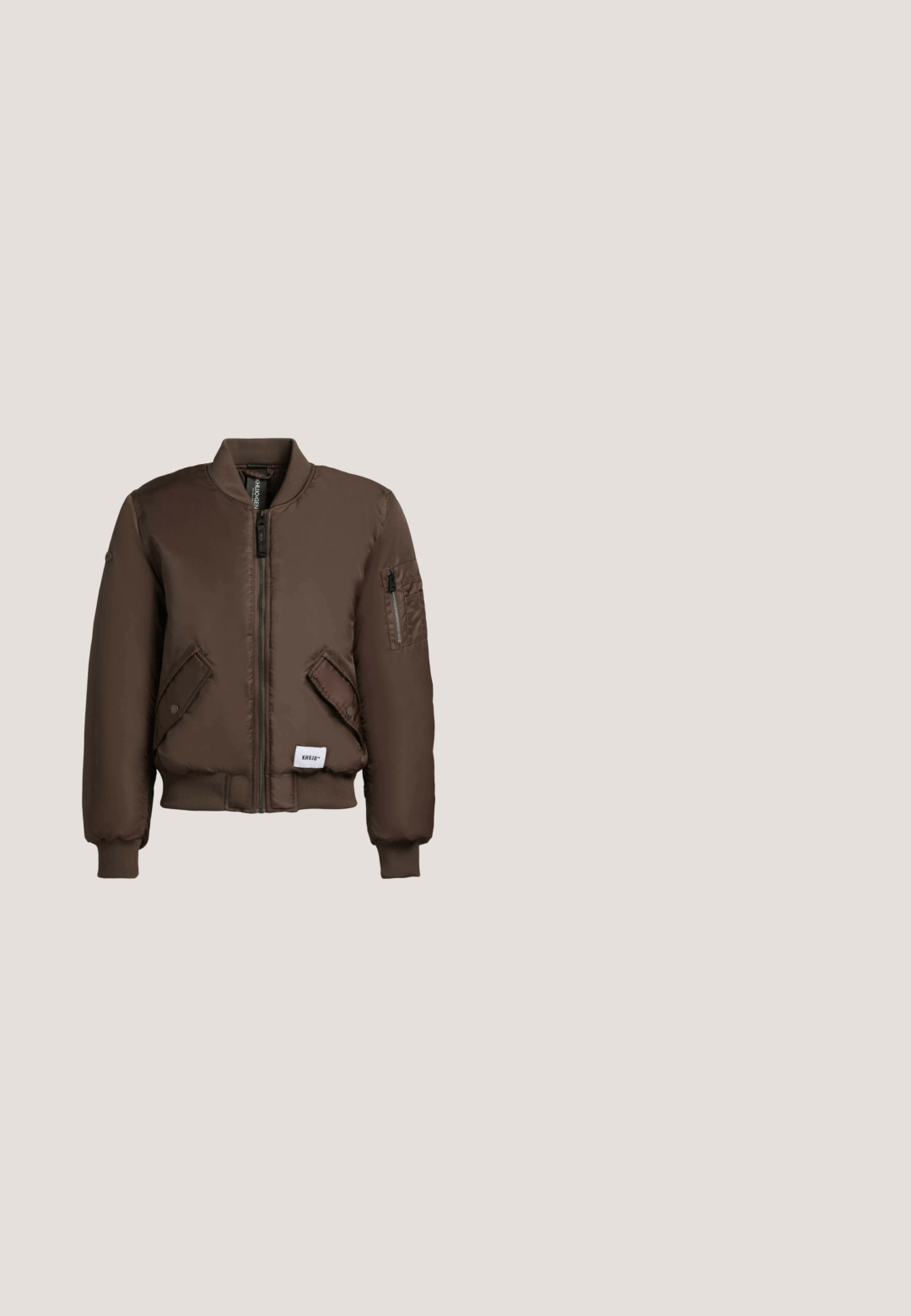 Bruine bomberjack met geribde boorden en kraag, ritssluiting aan de voorkant, twee zakken met drukknopen en een ritssluiting zak op de linkermouw.; Bruine cropped T-shirt met grote gotische tekst "True Religion brand jeans" en een vage hoefijzergrafiek op de achtergrond.; Wijd-uitlopende denim jeans in medium blauw, met een klassiek ontwerp met vijf pockets, knoopsluiting en lichte vervaging voor extra textuur.; Sneakers met een mix van beige, roze en bruine materialen. Suède en stoffen texturen met logodetails en een gevoerde zool.; Bruine leren schoudertas met ritssluiting en gouden "REPLAY SINCE 1981" logo aan de voorkant tegen een lichte achtergrond.; Roze gouden metalen oorbellen met een geometrisch ontwerp met een rechthoekige en cirkelvormige vorm, een gladde oppervlakte en subtiele branding.