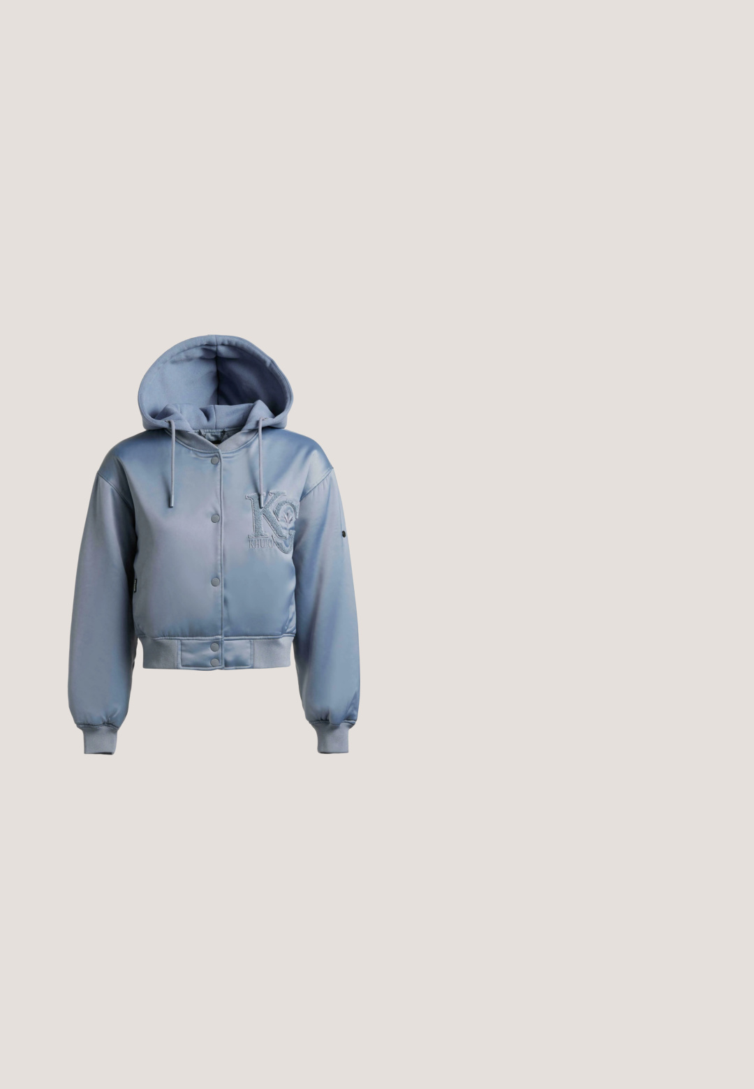 Blå cropped hættejakke med trykknapper foran, ribkant ved ærmer og kant, og tekstureret "KG KHUJO" logo på brystet.; Lysblå hætte sweatshirt lavet af blød stof, med glitrende tekst og dekorative detaljer på ærmerne. Ribbestrikkede manchetter og kant.; Cremefarvet t-shirt i blød bomuld med oversized korte ærmer, rund halsudskæring og et blå spraymalet logo med teksten "Low Lights Studios."; Turkise joggerbukser lavet af blødt stof, med elastisk talje, elastiske manchetter og dekorative sommerfugleudsmykninger.; Damesneakers med blåt blomstermønsterstof, lys grå ruskind, hvide snørebånd, metalliske sølvdetaljer og en hvid sål med gummiydersål, mærket LIU JO.; Metallisk sølvfarvet quiltet håndtaske med polstrede håndtag og aftagelig rem, ledsaget af en mindre matchende lynlåspung.