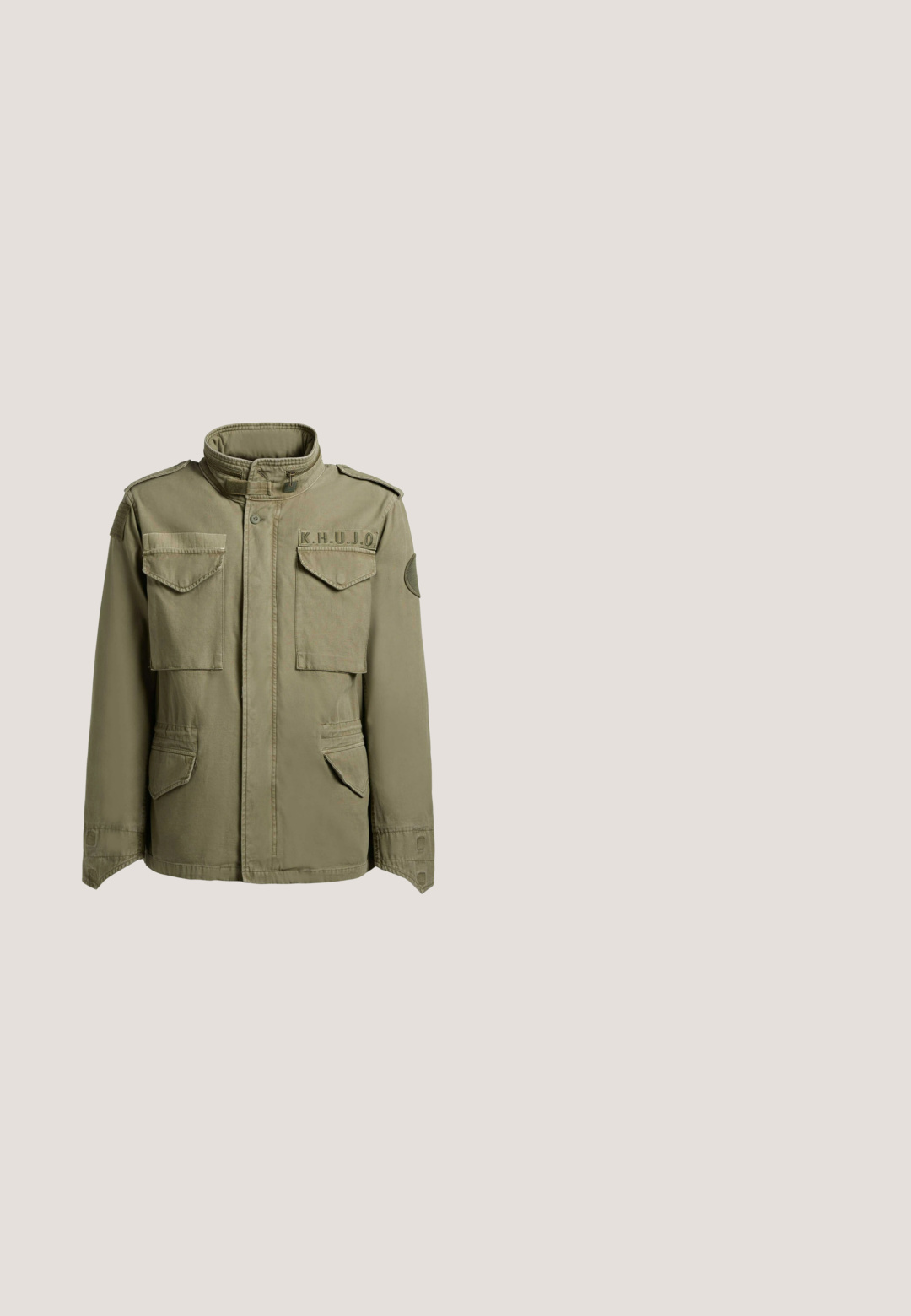 Olijfgroene militaire jas met hoge kraag, vier klepzakken aan de voorkant, schouderepauletten en een "K.H.U.J.O"-patch op de borst.; Olijfgroen katoenen T-shirt met een relaxte pasvorm, featuring een ronde hals en "KANI" in vetgedrukte letters over de borst.; Camouflage cargo shorts in groen en wit, met meerdere zakken, een ritssluiting en zwarte koordaccenten. Katoenen stof met een comfortabele pasvorm.; Groene rubberen laars met een zwarte stoffen boord en trekkoord. Gestructureerd oppervlak met een gladde afwerking. Voorzien van een logodetail aan de zijkant.; Vierkante pilotenstijl zonnebril met dunne bronzen metalen montuur en donkere groene glazen, schuin geplaatst op een witte achtergrond.; Vierkante crossbodytas met een voorvak met ritssluiting in donkergroen, een grijze hoofdkleur en een brede grijze schouderband.