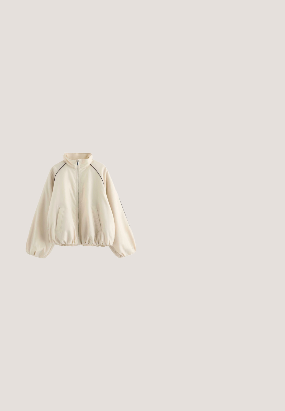 Beige jakke med lynlås, høj krave, elastisk kant og ærmegab, to forlommer samt sort piping langs skuldersømmene.; Beige hættetrøje med forlommekangurupung og lille hvidt logo på brystet, med ribstrikkede manchetter og kant.; Beige bomulds t-shirt med korte ærmer, rund halsudskæring og hvid skråskrift på fronten, der står "Pegador Dreams Come True."; Beige vidbenede sweatpants med elastisk talje og sidelommer, med en lille broderet brandlogo på højre lår.; Beige og lysebrun atletisk sneakers med meshpaneler, tyk polstret sål, snørelukning og træktab på en hvid baggrund.; Beige skuldertaske i halvmåneform med justerbar rem og lynlås, lavet af blødt, struktureret stof.