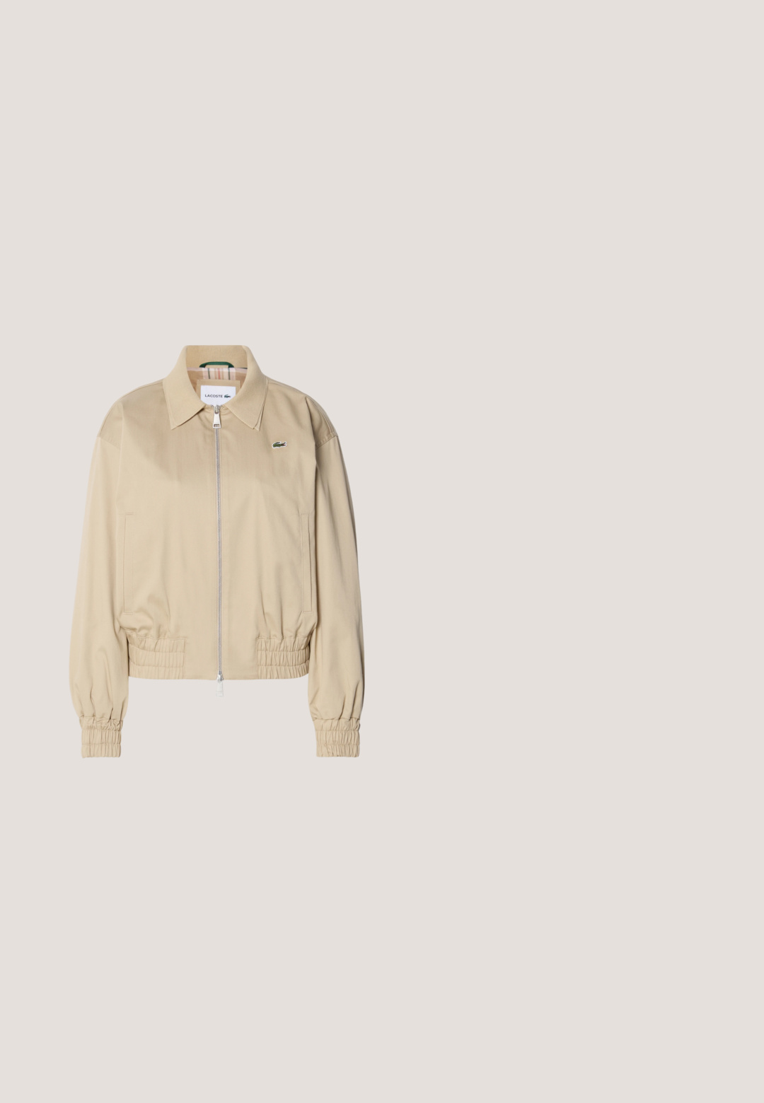 Beige cropped jakke lavet af letvægtsstof, med fuld lynlås, elastiske ærmer og et diskret logo på brystet.; Lyserød hoodie lavet af blødt stof, med en kengurulomme, justerbar snøre-hætte, og et lille grønt krokodillelogo på brystet.; Lyserød bomulds T-shirt med korte ærmer, rund halsudskæring og lille grøn Lacoste-logo på venstre bryst. Blød tekstur, afslappet pasform.; Lyserøde sweatpants med elastisk talje, tapede ben og sammenfoldede elastiske manchetter ved anklerne, på en ensfarvet baggrund.; Løbesko med pink, beige og cremet mesh samt syntetiske overlays, kraftig sål og tekstureret ydersål for greb, set fra siden.; Lyserød tote-taske med to lange håndtag, lynlås og lille sølv krokodillelogo foran i midten.