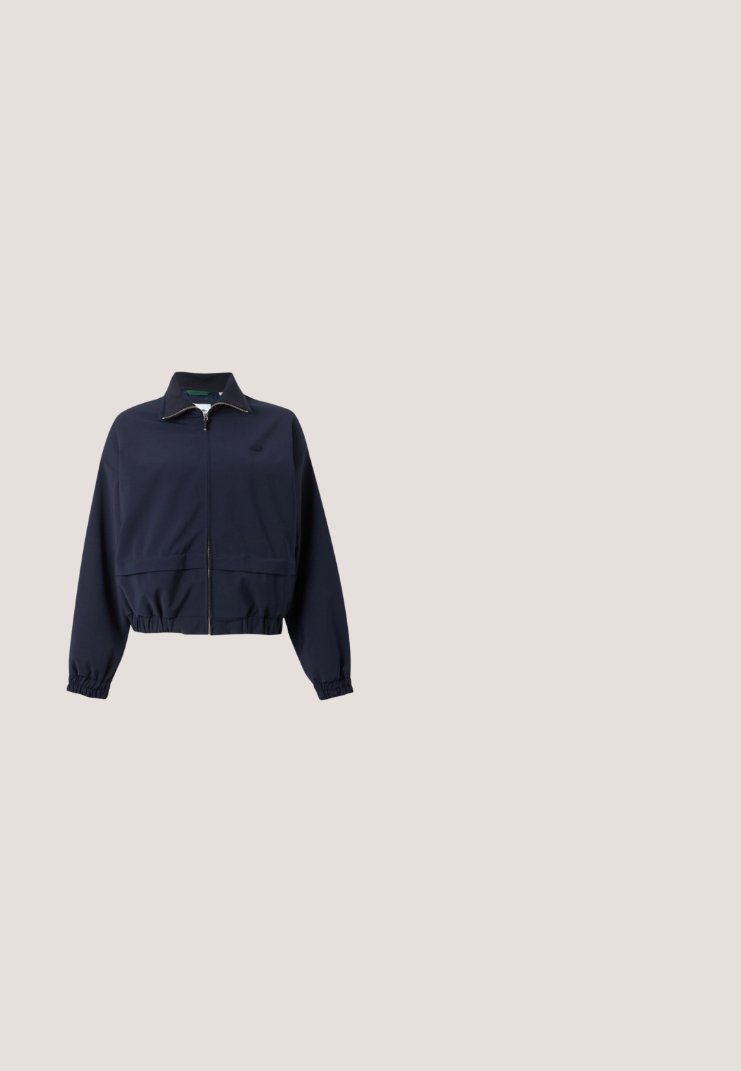 Chaqueta ligera azul marino con cremallera frontal completa, cuello alto, puños elásticos y cintura elástica, mostrada sobre un fondo liso.; Sudadera blanca de manga larga con cremallera de cuarto, con puños y dobladillo acanalados, que presenta un pequeño logo de cocodrilo bordado en verde en el pecho.; Jersey de manga larga Lacoste en gris claro con cuello, tres botones, puños acanalados y un pequeño parche con el logo verde en el pecho.; Pantalones de pierna ancha en color blanco con cinturilla elástica, textura de tela suave, pliegues en el centro y un pequeño logo de Lacoste bordado en el costado.; Zapatillas deportivas blancas con parte superior de malla, diseño texturizado y cuello acolchado. Cuenta con un logo verde en el lateral y una suela acolchada para mayor comodidad.; Pequeño bolso azul marino con estampado blanco de raqueta de tenis, logo verde de cocodrilo, asas cortas y correa de hombro ajustable.