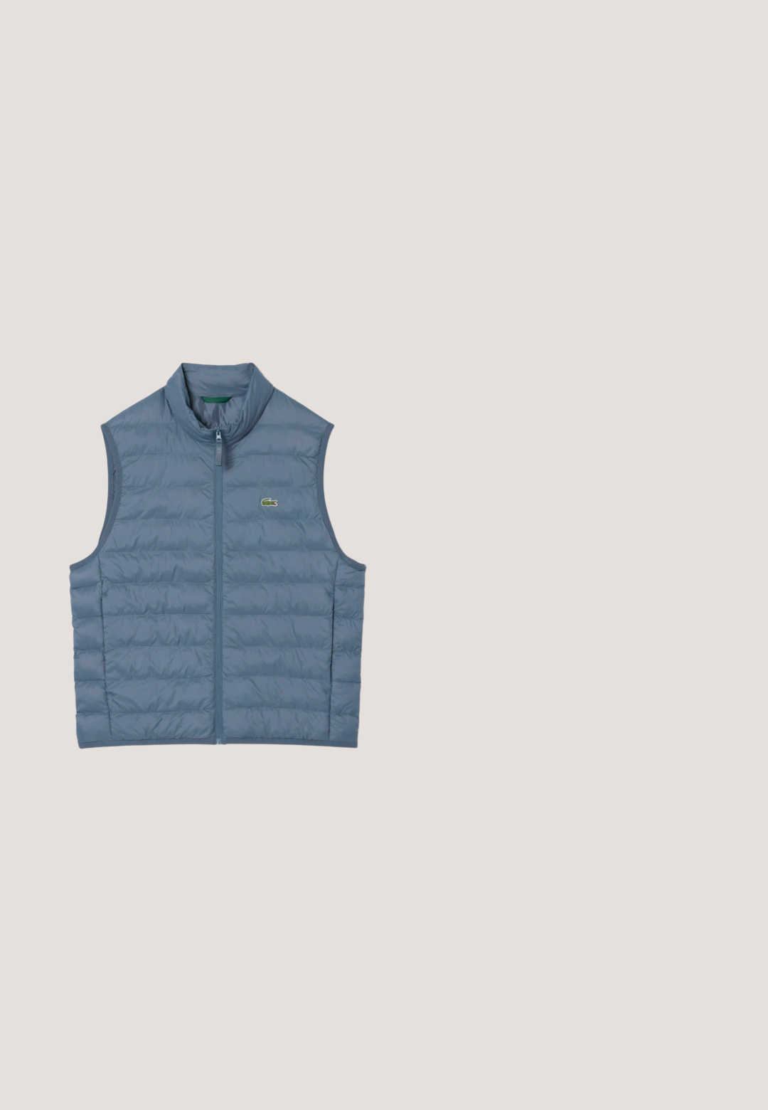 Chaleco azul acolchado sin mangas con cremallera frontal y pequeño logo de cocodrilo verde en el pecho.; Suéter azul marino con cuello de media cremallera, puños y dobladillo acanalados, hecho de una tela suave, presenta un pequeño logo de cocodrilo verde en el pecho.; Camisa polo blanca hecha de algodón, con un cuello clásico, mangas cortas y un pequeño logotipo bordado en el pecho izquierdo.; Lacoste Pantalones - bleu marine hde; Zapatilla blanca con acentos de ante beige y rayas marinas. Presenta una suela de goma texturizada y un pequeño logo de cocodrilo verde en el lateral.; Bolso bandolera Lacoste azul marino con correa ajustable y parche con logotipo en la solapa frontal, sobre un fondo claro y liso.